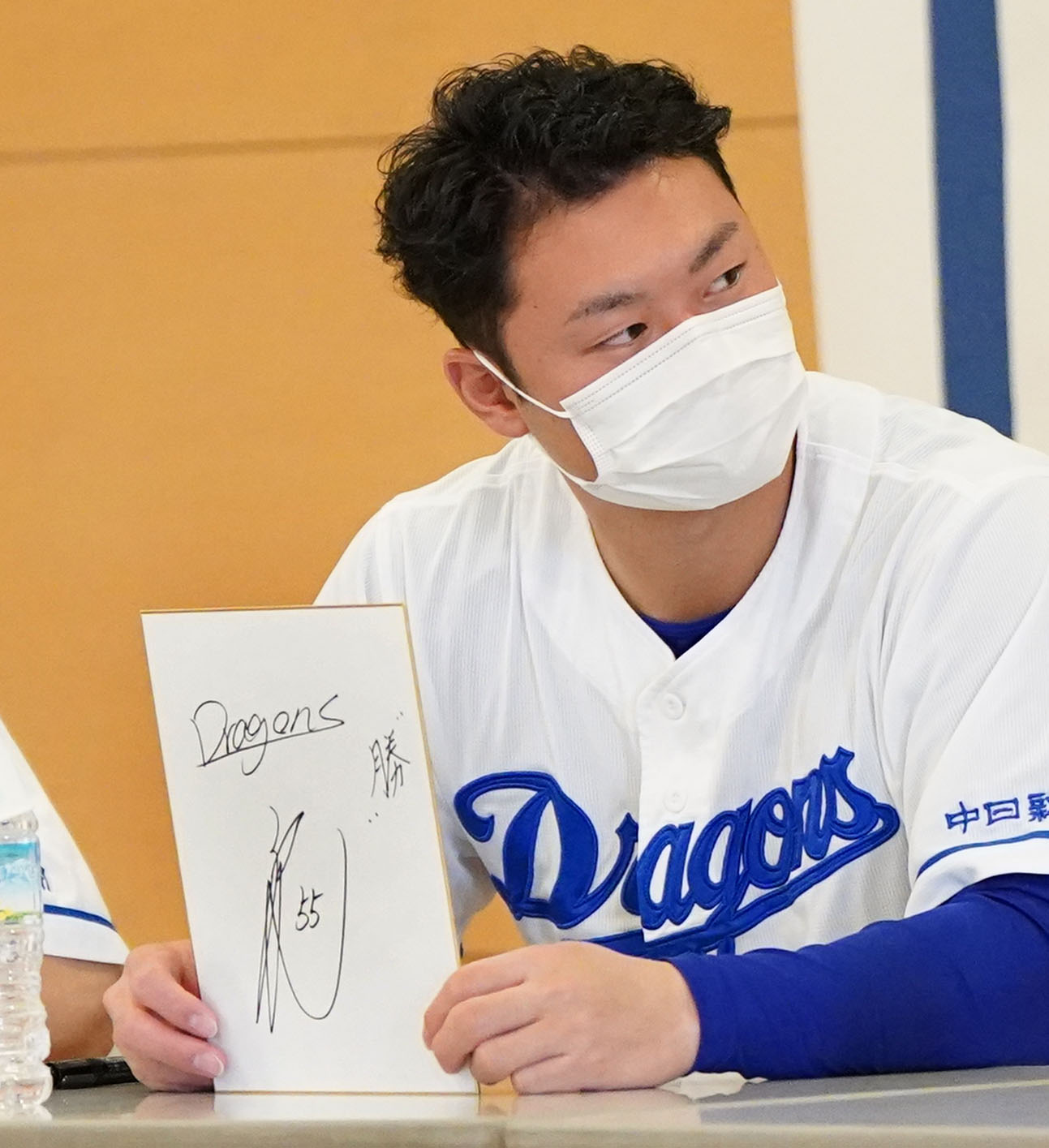 病院を慰問しイベント内で、来季の抱負を漢字一文字で「勝」と新背番号55を色紙に記す細川（撮影・森本幸一）