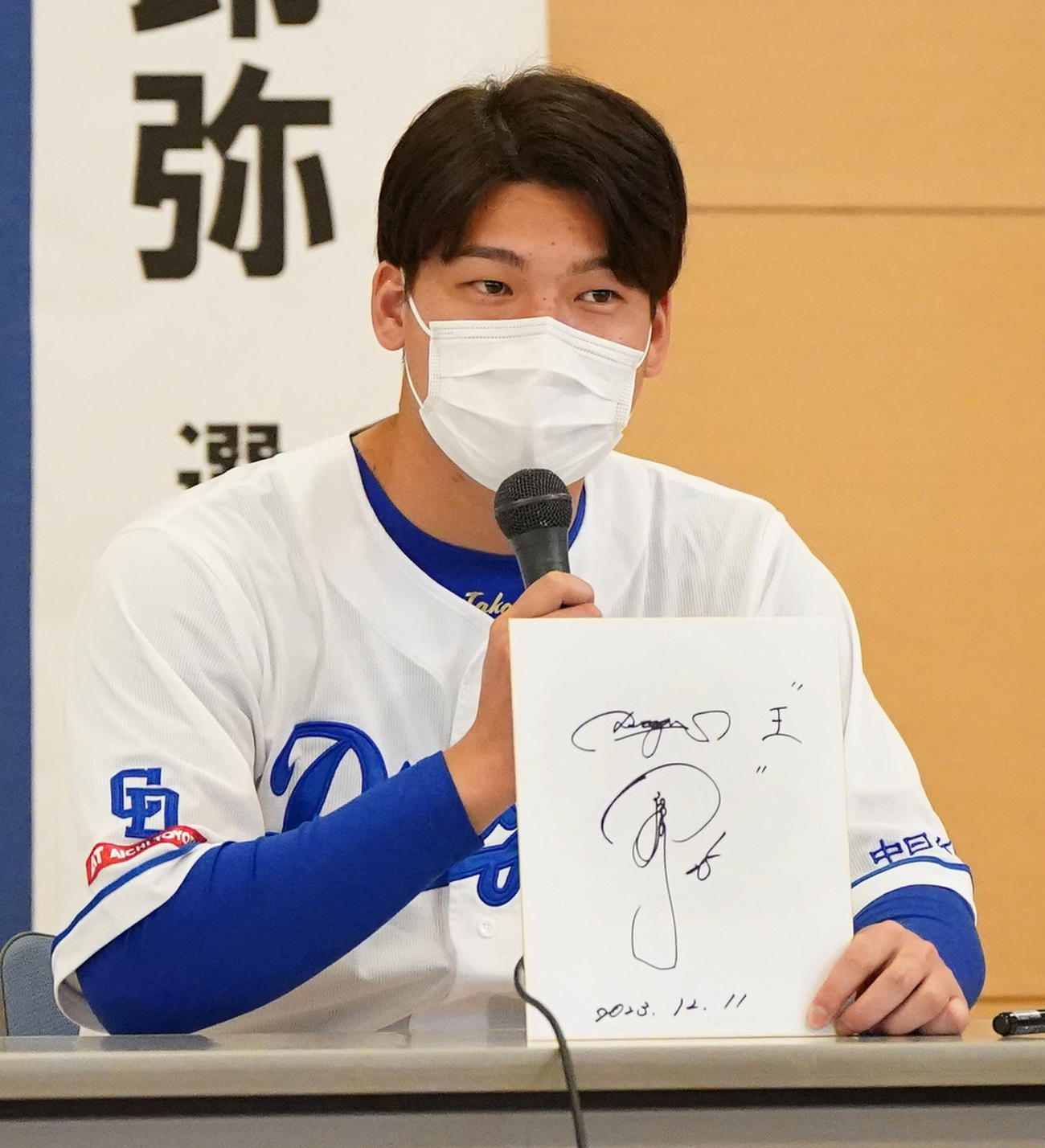 病院を慰問しイベント内で、来季の抱負を漢字一文字で「王」と色紙に記す石川昂（撮影・森本幸一）