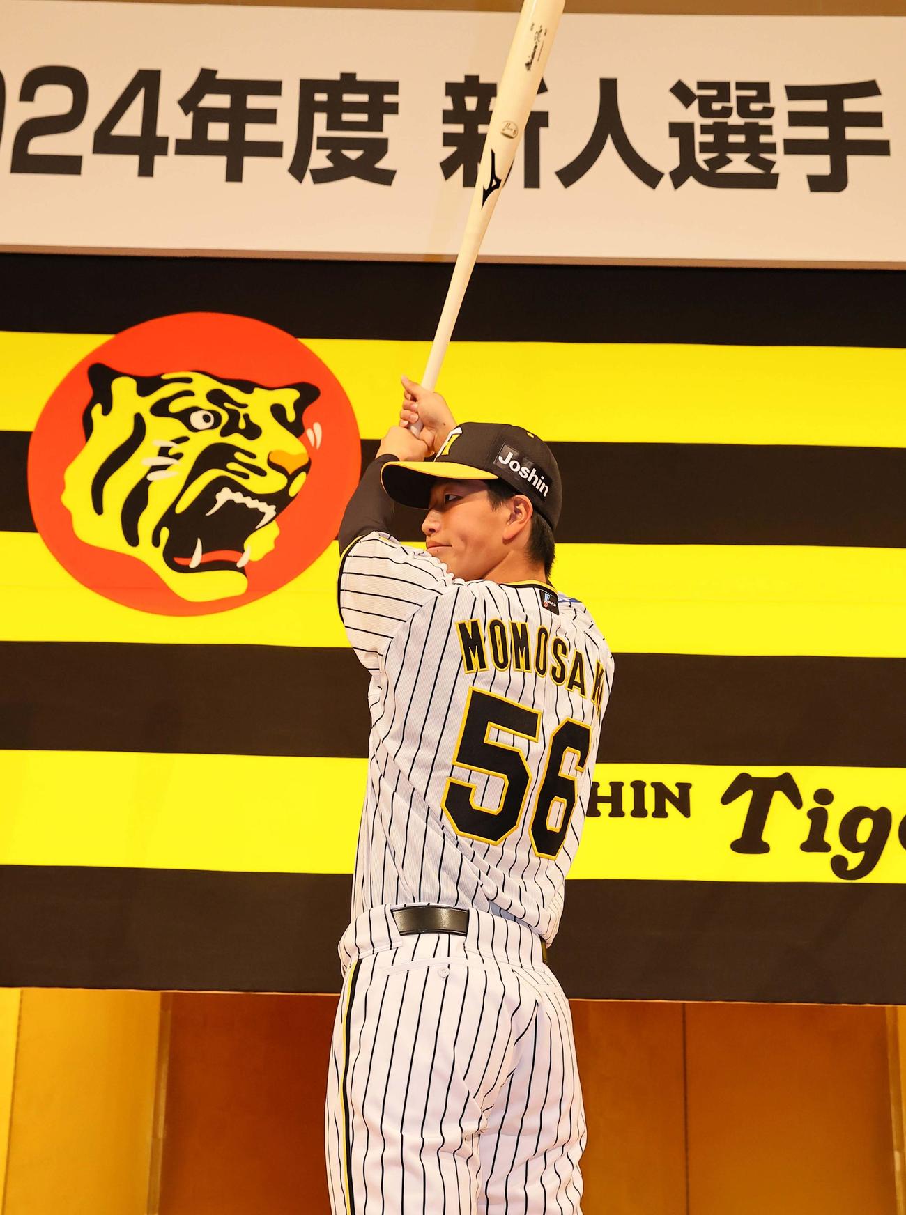 笑顔でポーズを決めるドラフト4位百崎（撮影・上田博志）