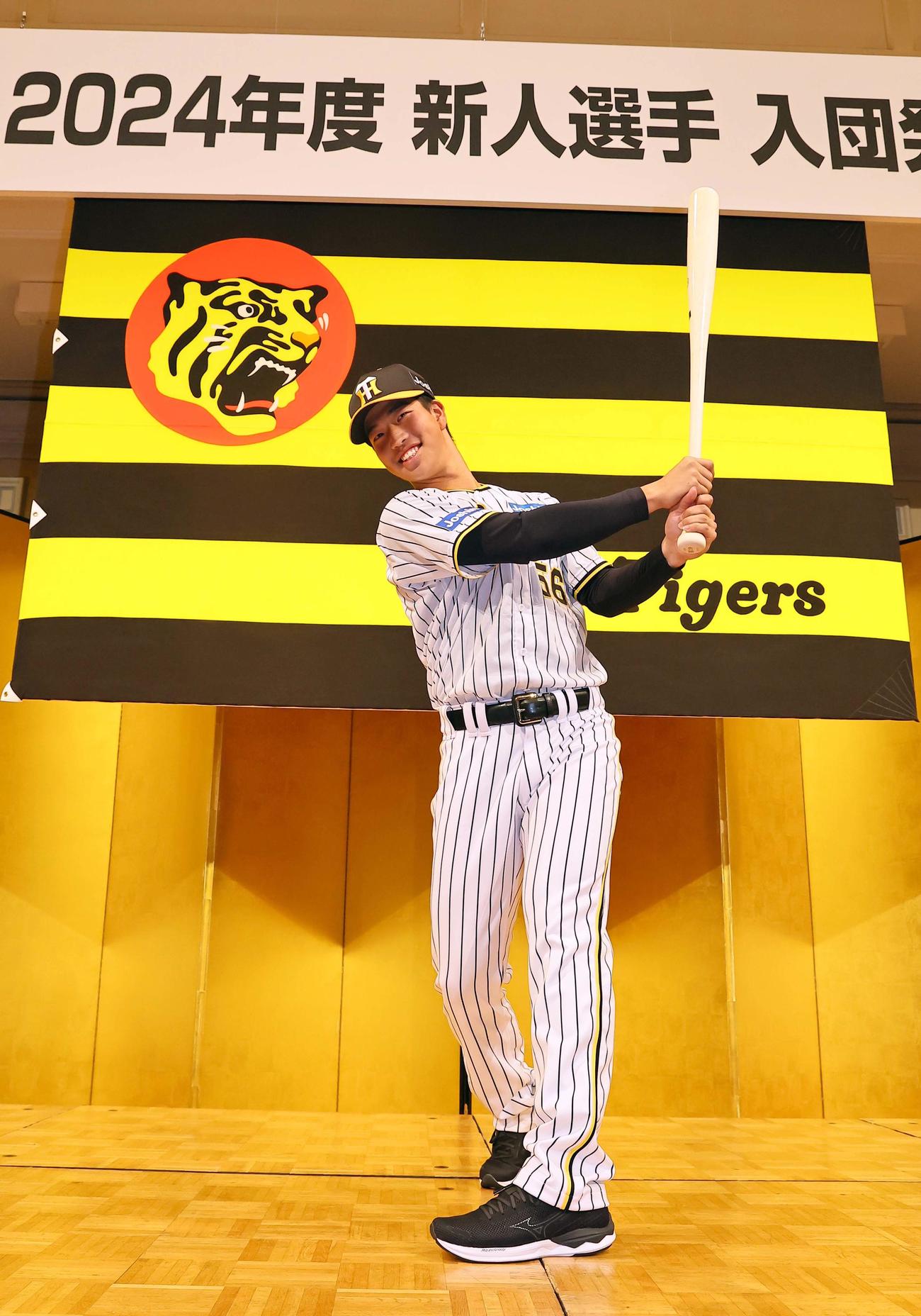 笑顔でポーズを決めるドラフト4位百崎（撮影・上田博志）