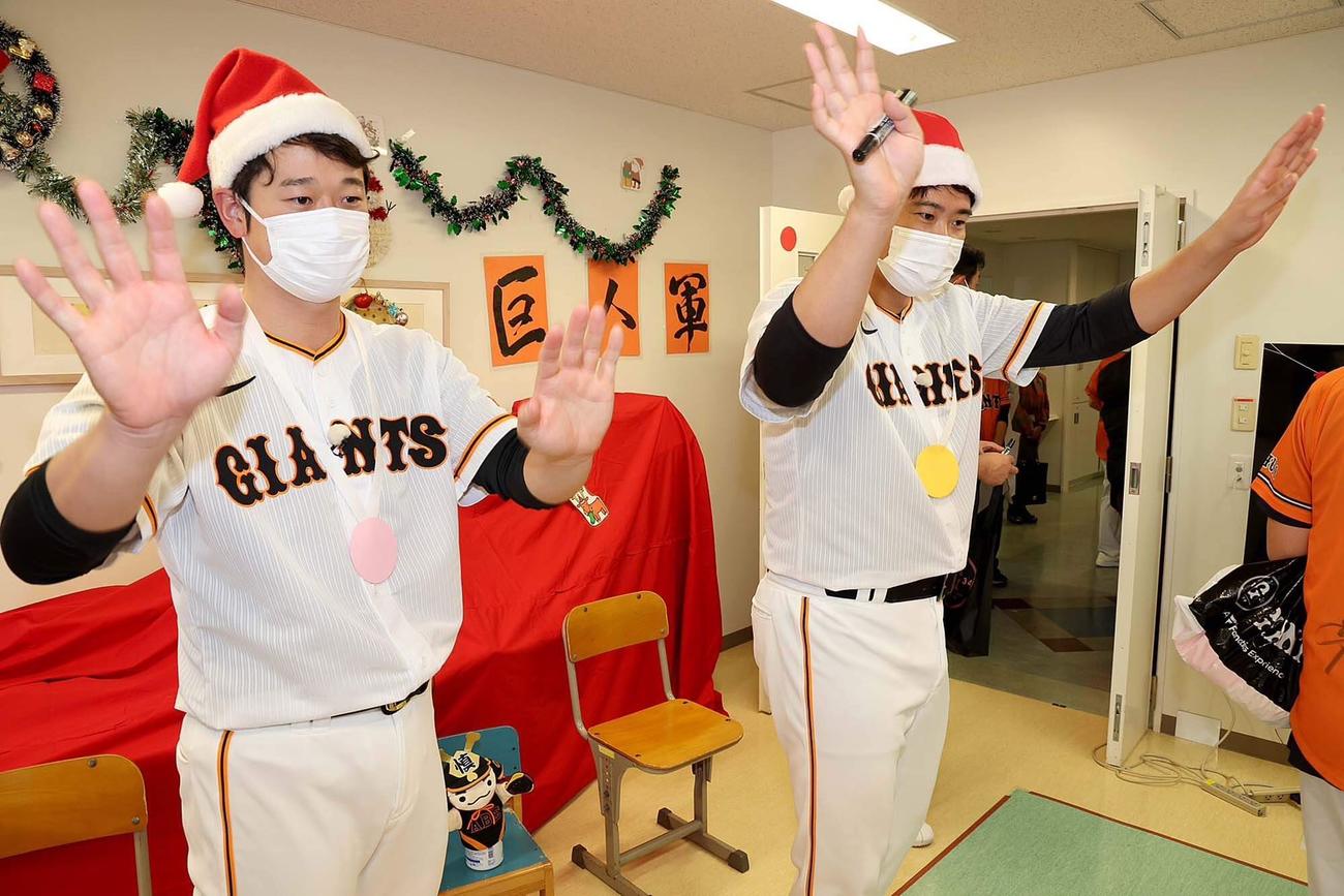サンタクロースの帽子を被って子供と交流し、笑顔の巨人中川（左）と菅野（球団提供）