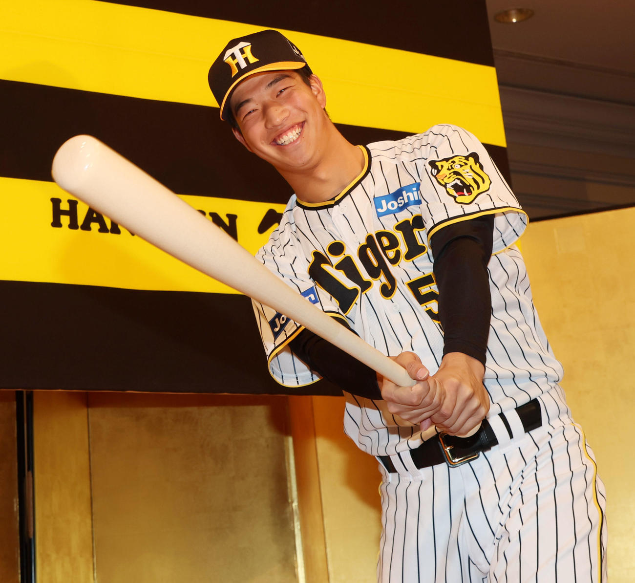 新人選手入団会見でバット手に笑顔を見せる百崎（撮影・加藤哉）