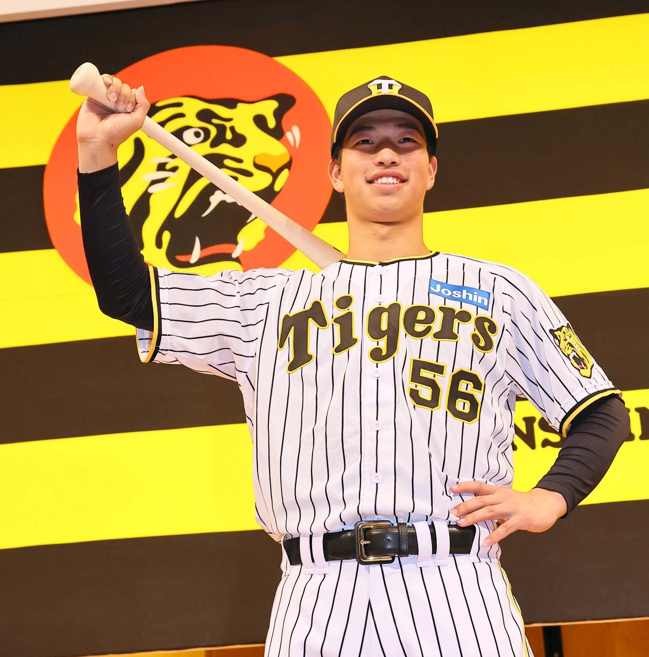 笑顔でポーズを決めるドラフト4位百崎（撮影・上田博志）