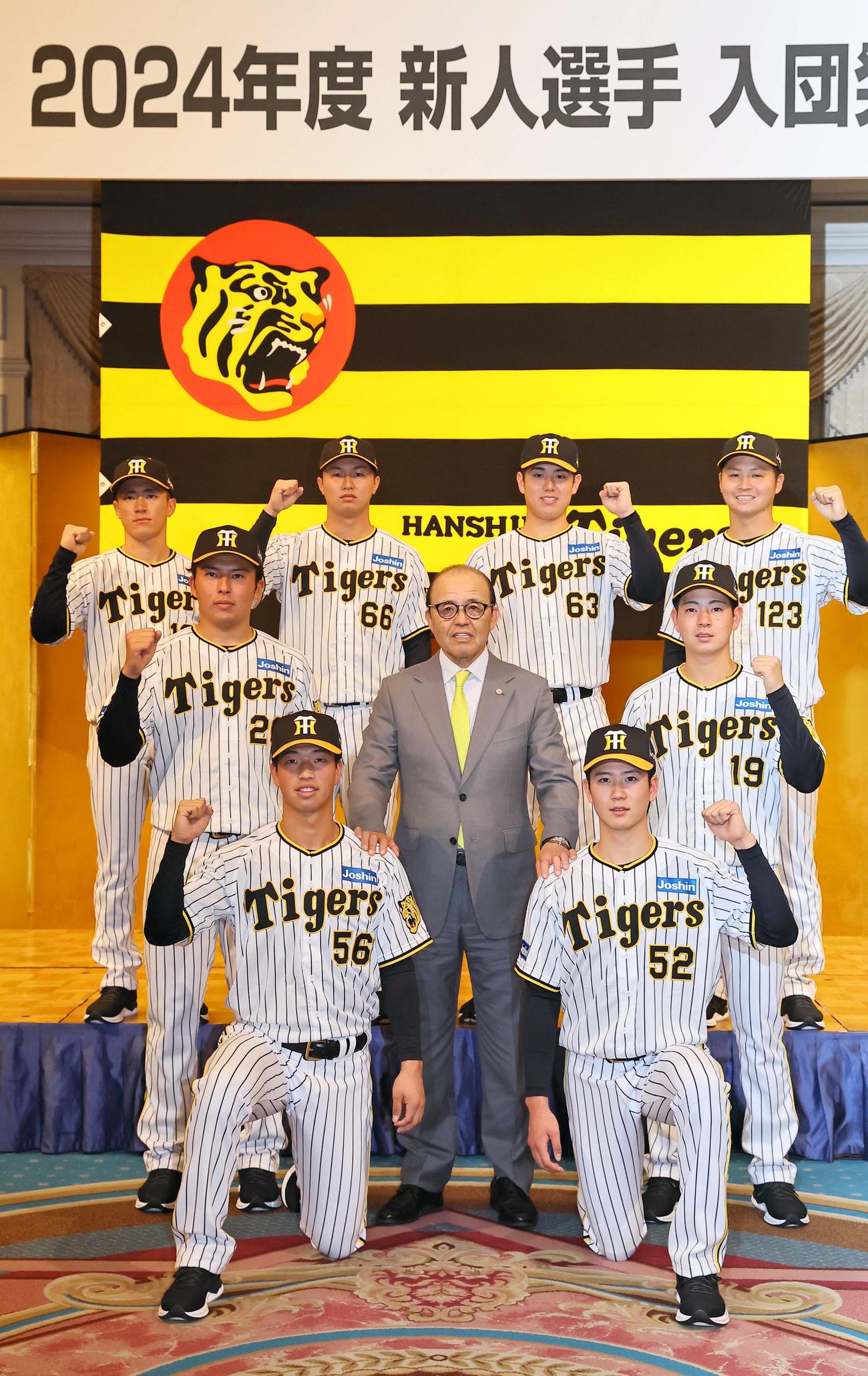 ガッツポーズで笑顔を見せる2024年度阪神新入団選手、下段左からドラフト4位百崎、ドラフト3位山田、中段左からドラフト2位椎葉、岡田監督、ドラフト1位下村、上段左から育成ドラフト2位福島、ドラフト6位津田、ドラフト5位石黒、育成ドラフト1位松原（撮影・上田博志）