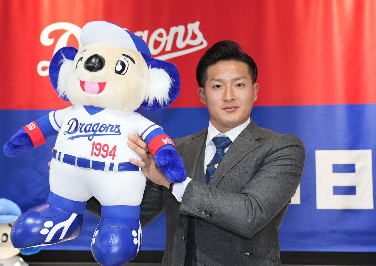 入団会見後、ドアラのぬいぐるみを手にポーズを決める梅野（撮影・森本幸一）