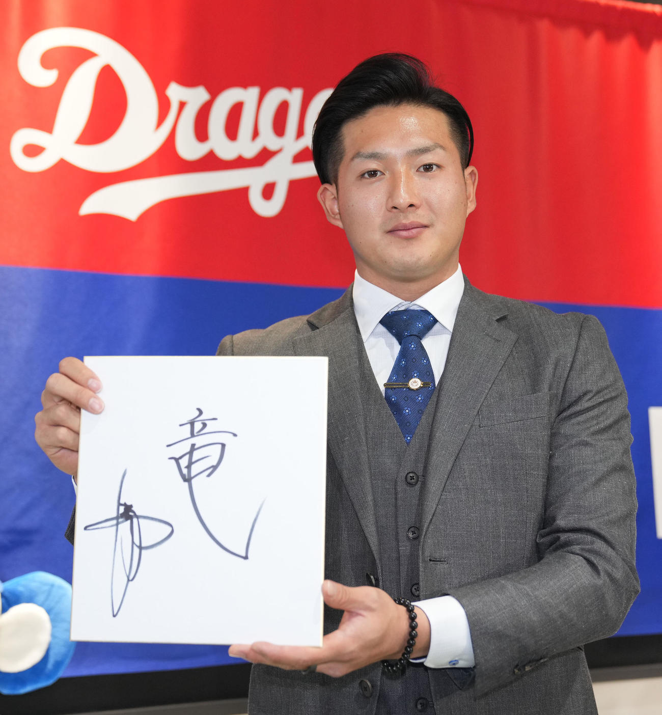 入団会見後、来季の1文字を心機一転の意を込め「竜」と色紙に記しポーズを決める梅野（撮影・森本幸一）