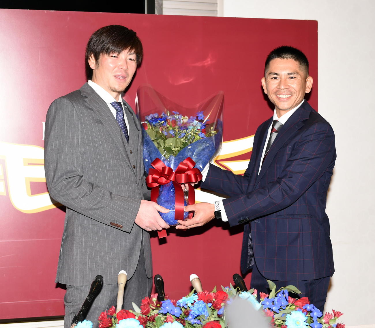 引退会見後に同学年で球団職員の福山氏（右）から花束を受け取った楽天塩見（撮影・山田愛斗）