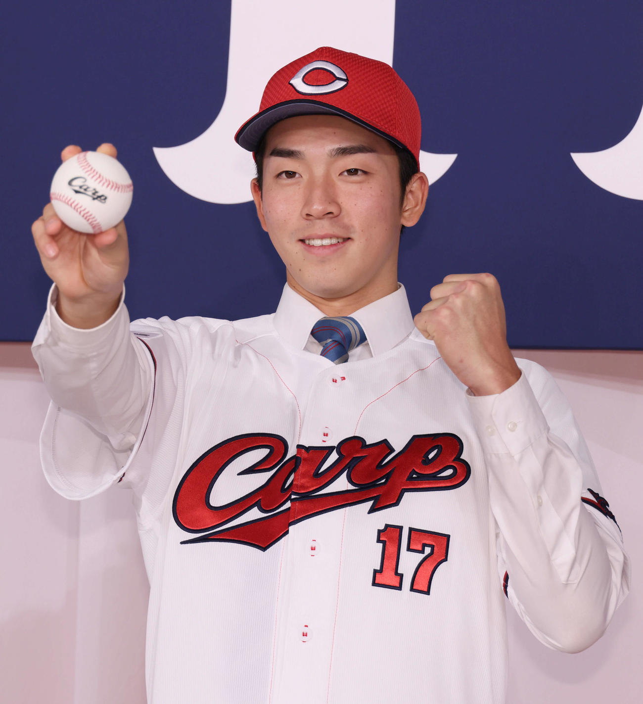 広島新入団選手会見　ポーズを決めるドラフト1位の常広（撮影・加藤孝規）