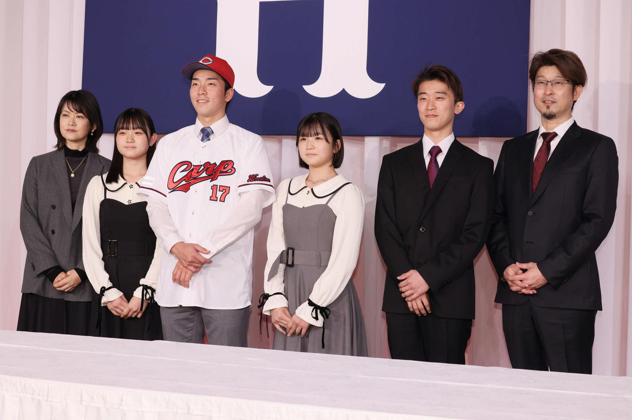 広島新入団選手会見で家族と写真に納まるドラフト1位の常広（左から3人目）（撮影・加藤孝規）