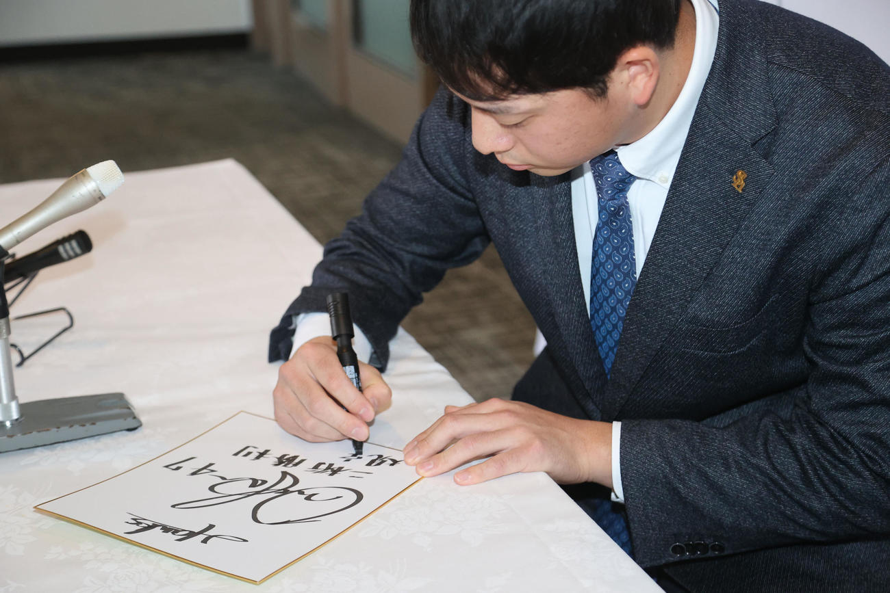 「47」で来季の目標とサインを色紙に書き入れる大関（撮影・梅根麻紀）