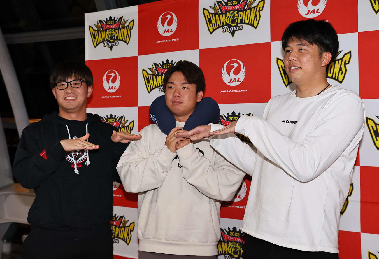 V旅行出発前にフラダンスポーズを見せる左から桐敷、村上、才木（撮影・上田博志）