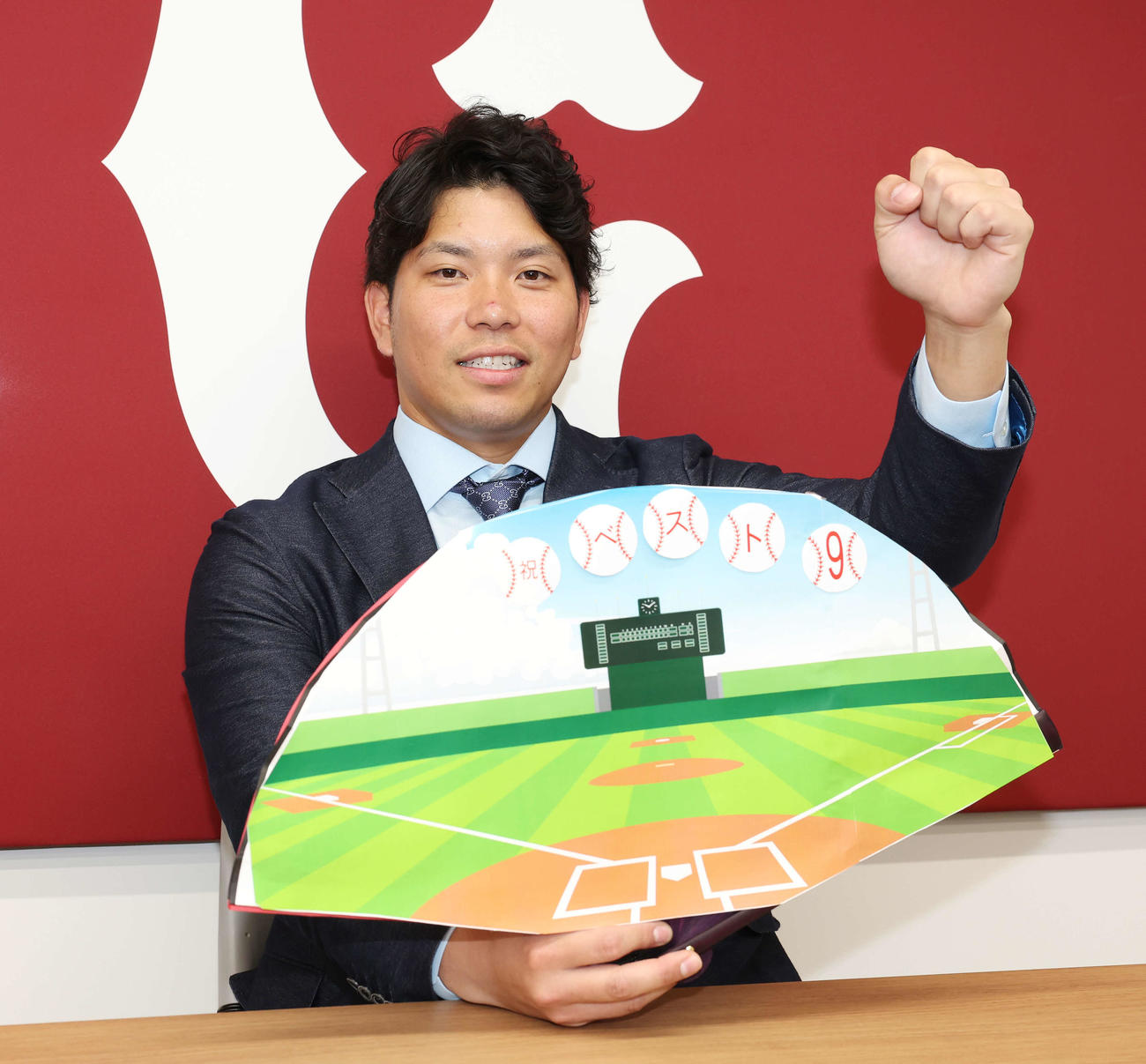 契約更改を終え、祝ベスト9のボードを手に笑顔でガッツポーズする巨人大城卓（撮影・宮地輝）