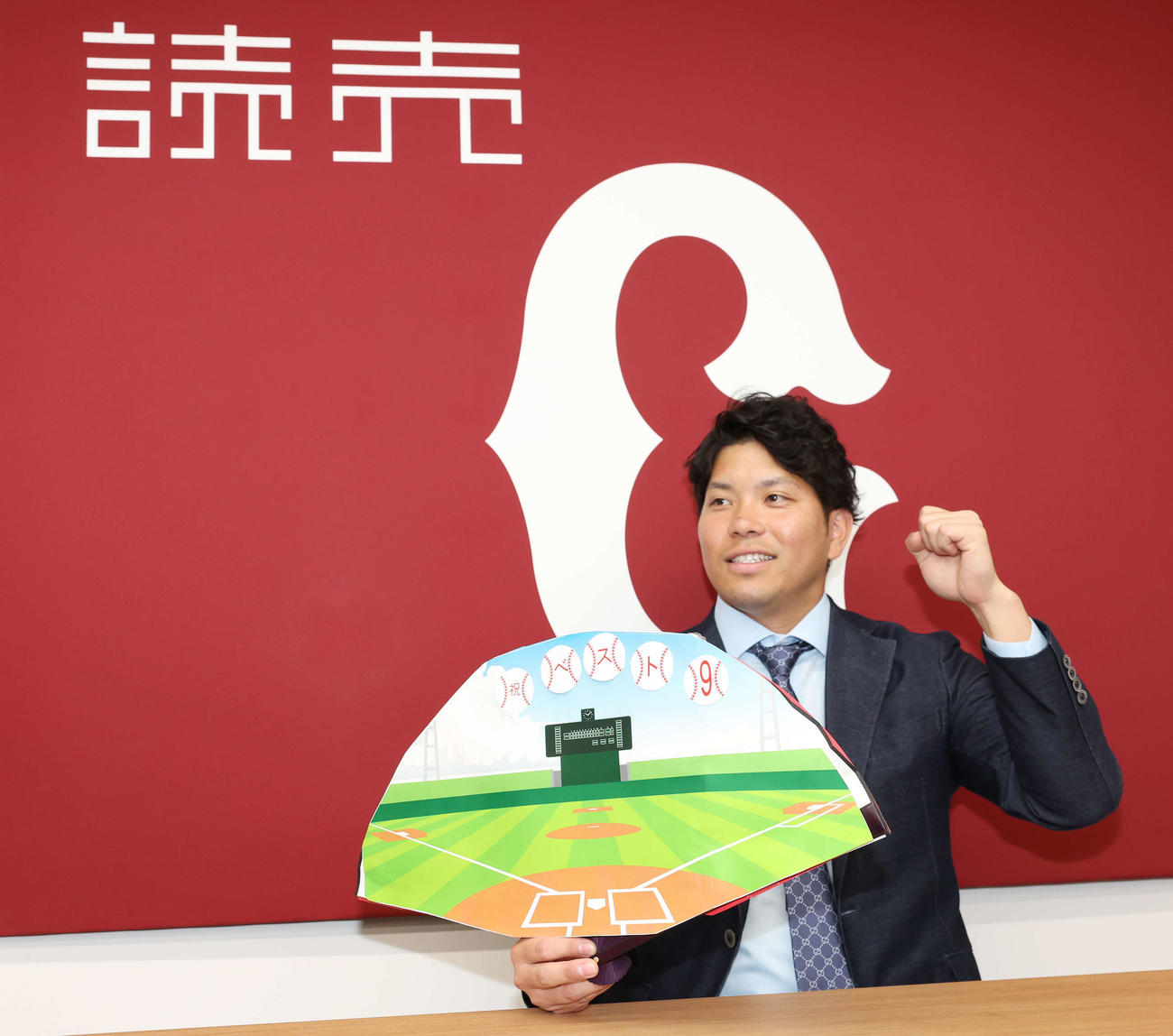 契約更改を終え、祝ベスト9のボードを手に笑顔でガッツポーズする巨人大城卓（撮影・宮地輝）
