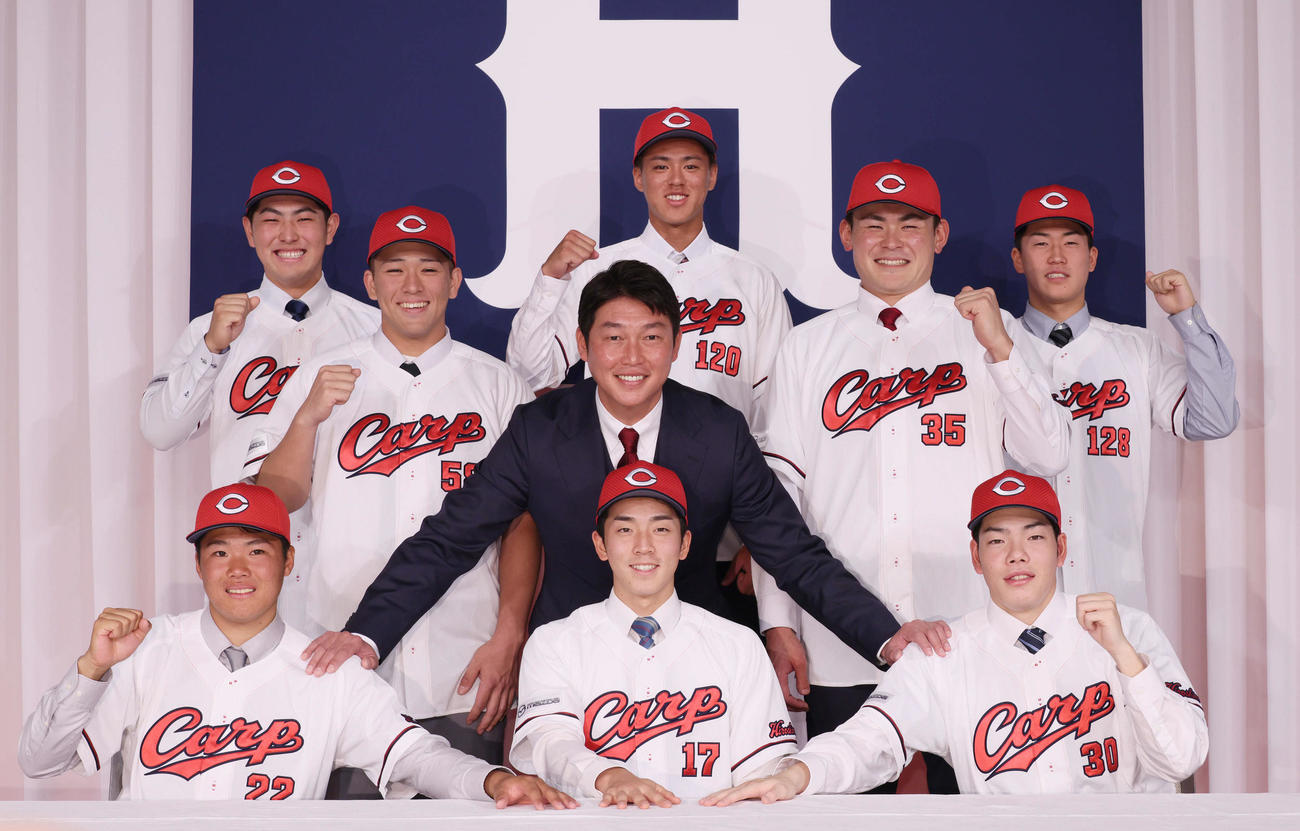 広島新井監督を中心に集合写真に納まる新入団選手たち。前列左からドラフト2位の高、ドラフト1位の常広、ドラフト3位の滝田、後列左から育成2位の佐藤、ドラフト4位の仲田、育英1位の杉田、ドラフト5位の赤塚、育成3位の杉原（撮影・加藤孝規）
