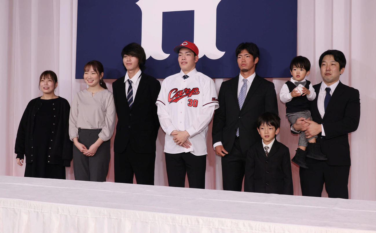 広島新入団選手会見　家族と写真におさまるドラフト3位の滝田（中央）（撮影・加藤孝規）