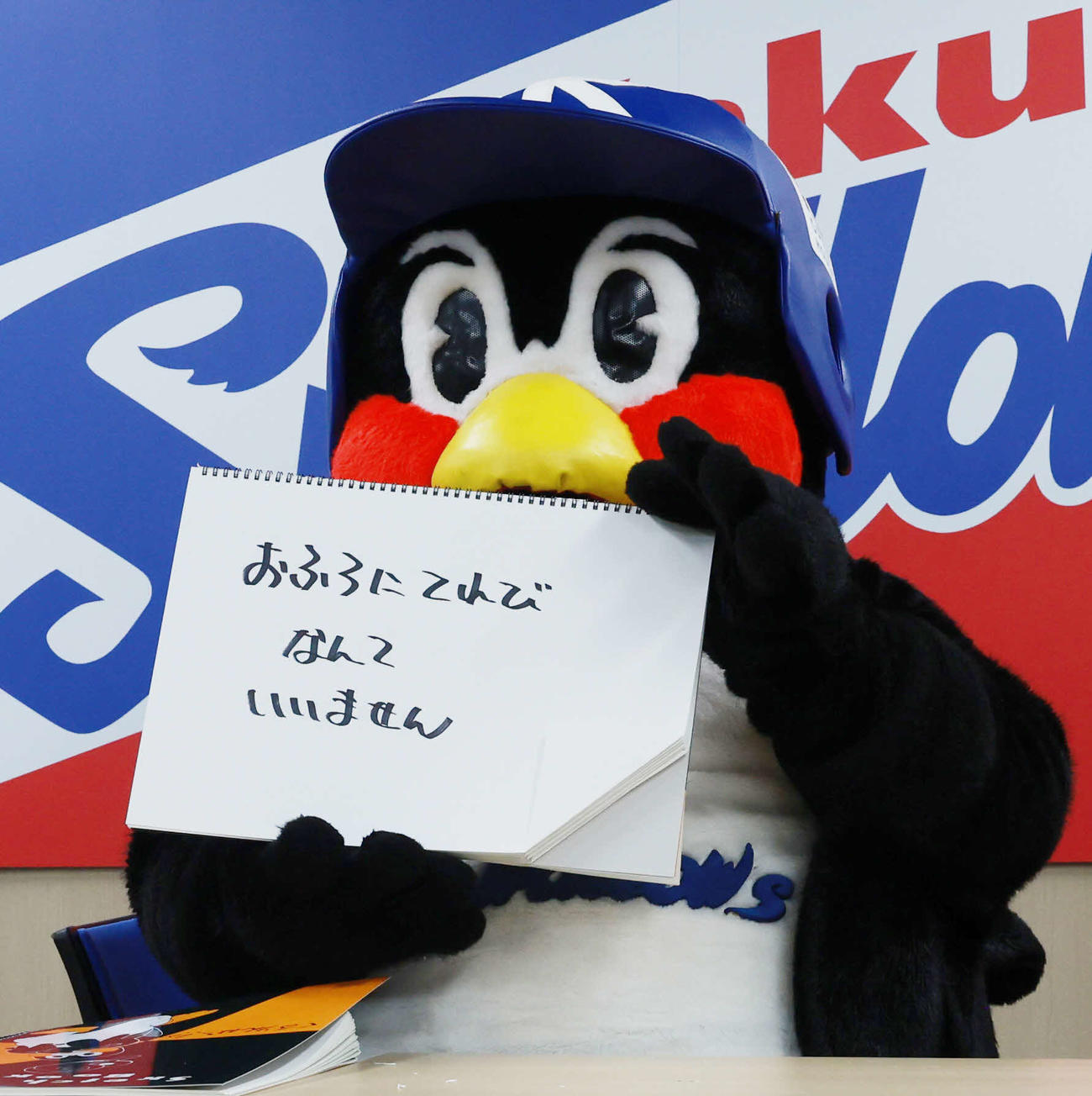 契約更改交渉を終え、フリップに「おふろにてれびなんていりません」と書くつば九郎（撮影・野上伸悟）
