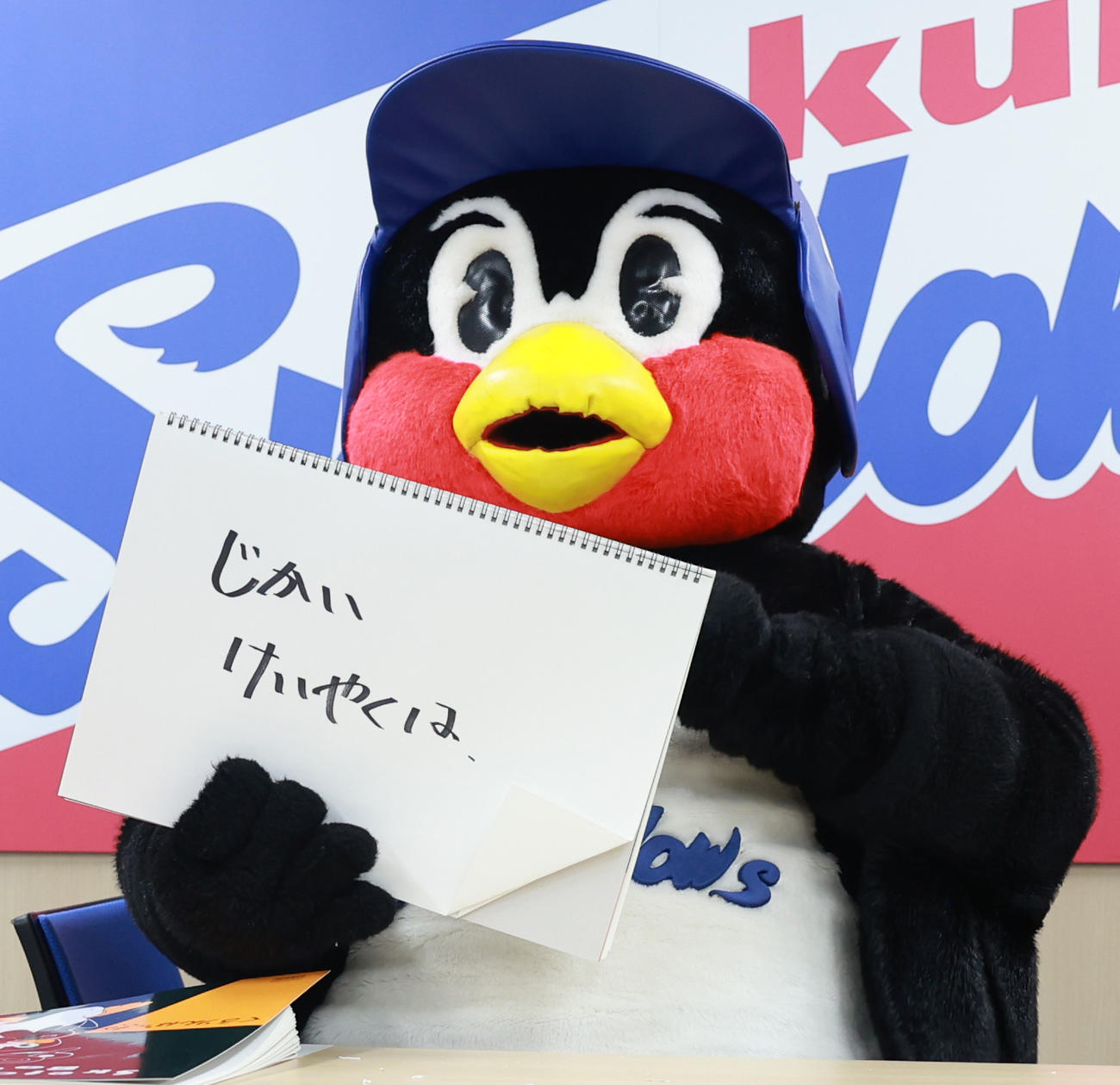 契約更改交渉を終え、フリップに「ほりゅうしました。えつねんです」と書くつば九郎（撮影・野上伸悟）