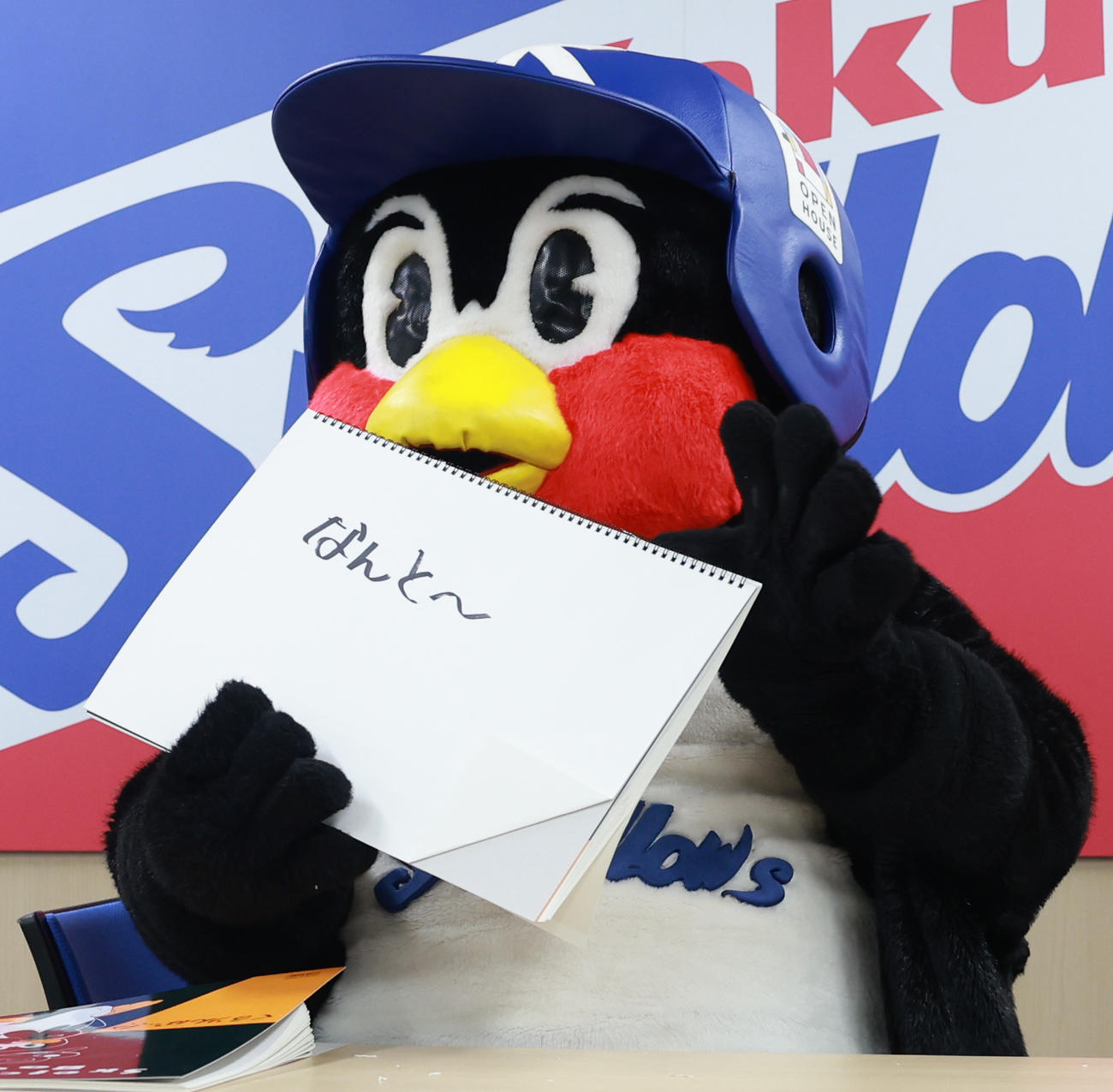 契約更改交渉を終え、フリップに「なんと～」と書くつば九郎（撮影・野上伸悟）