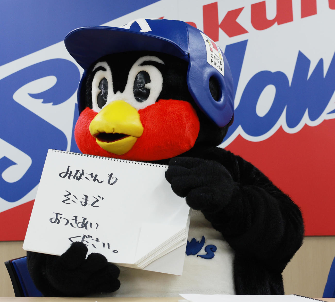 契約更改交渉を終え、フリップに「みなさんもそこまでおつきあいください」と書くつば九郎（撮影・野上伸悟）