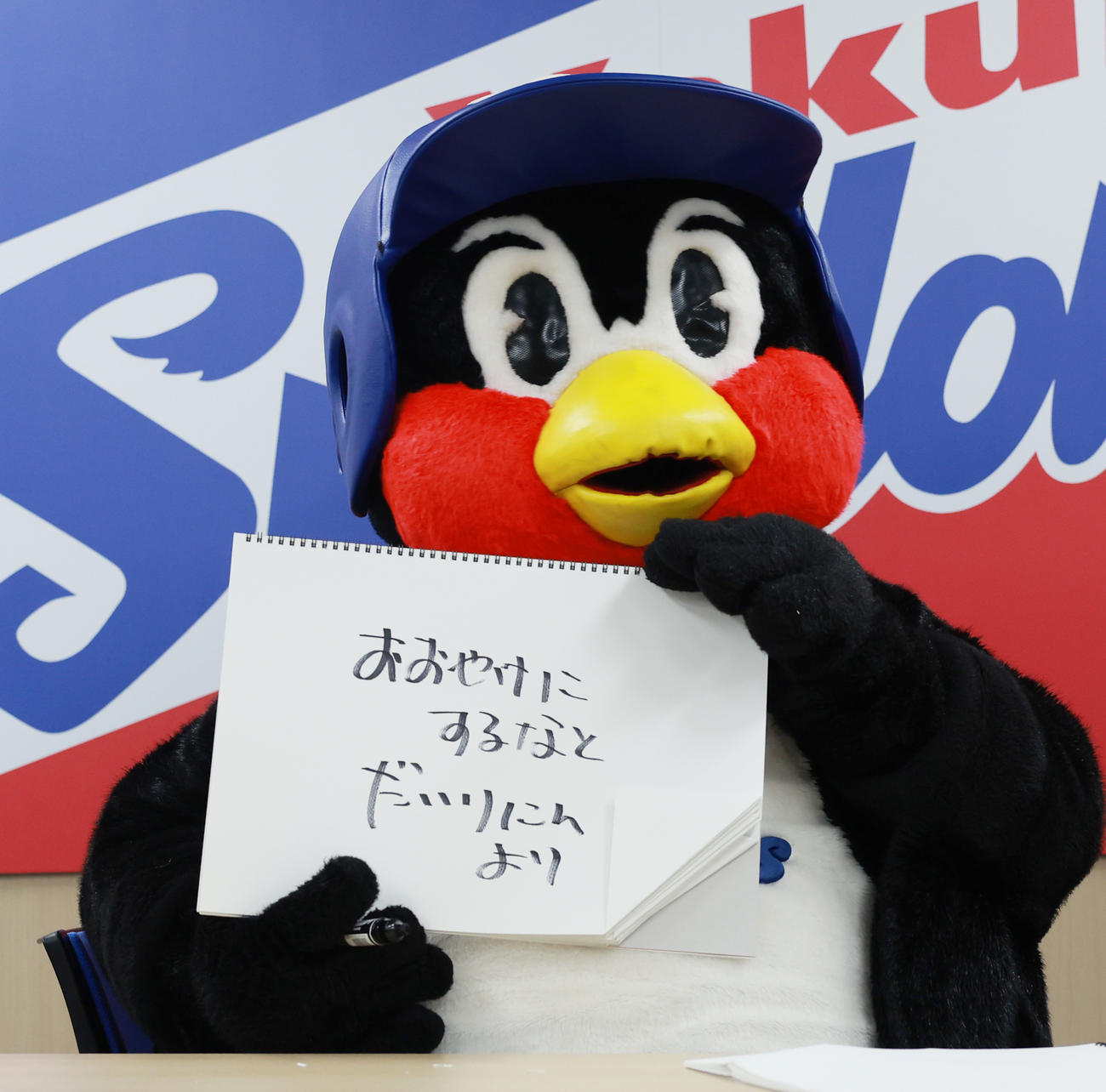 契約更改交渉を終え、フリップに「おおやけにするなとだいりにんより」と書くつば九郎（撮影・野上伸悟）