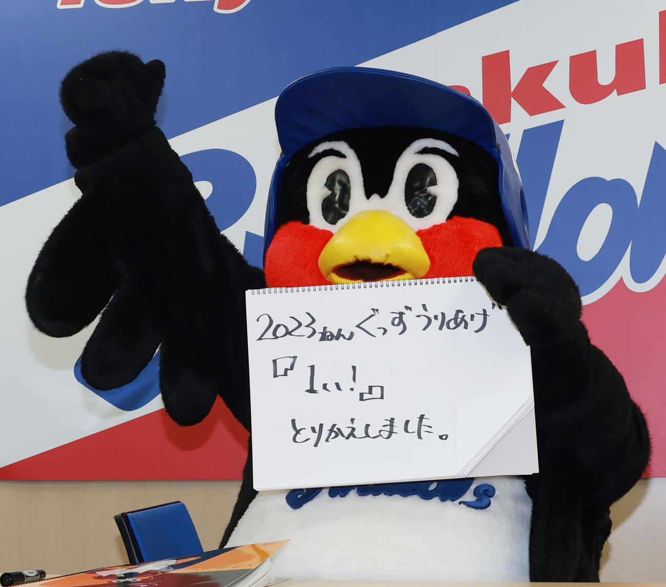 契約更改交渉を終え、フリップに「2023ねんぐっずうりあげ『1い！』とりかえしました」と書きガッツポーズのつば九郎（撮影・野上伸悟）