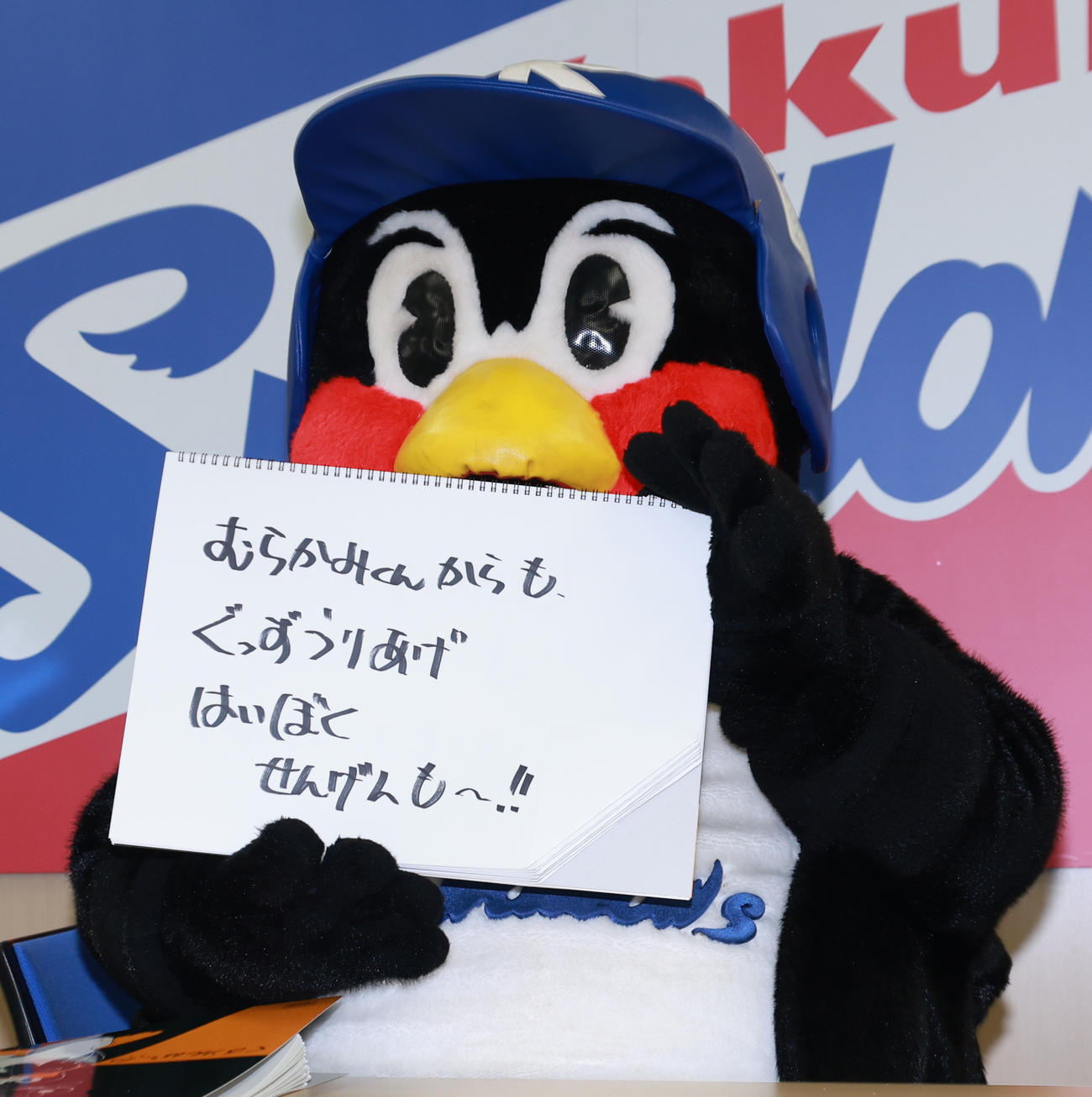 契約更改交渉を終え、フリップに「むらかみくんからも、ぐっずうりあげはいぼくせんげんも～！！」と書くつば九郎（撮影・野上伸悟）