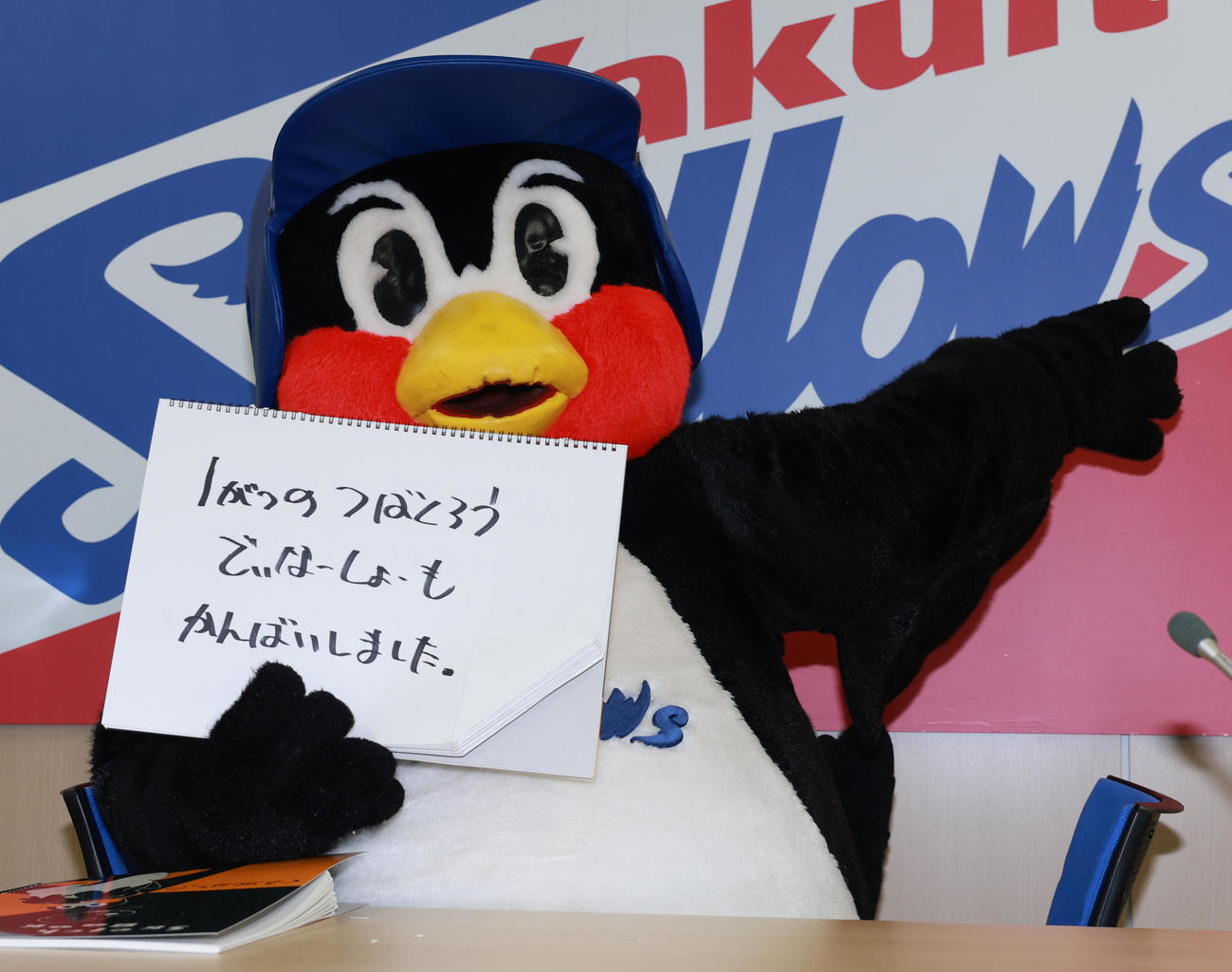 契約更改交渉を終え、フリップに「1がつのつばくろうでぃなーしょーもかんばいしました」と書くつば九郎（撮影・野上伸悟）
