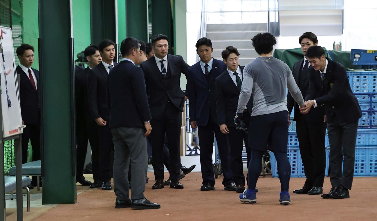 小笠原とあくしゅを交わす中日ドラフト1位草加（右）ら新入団の選手たち（撮影・上田博志）