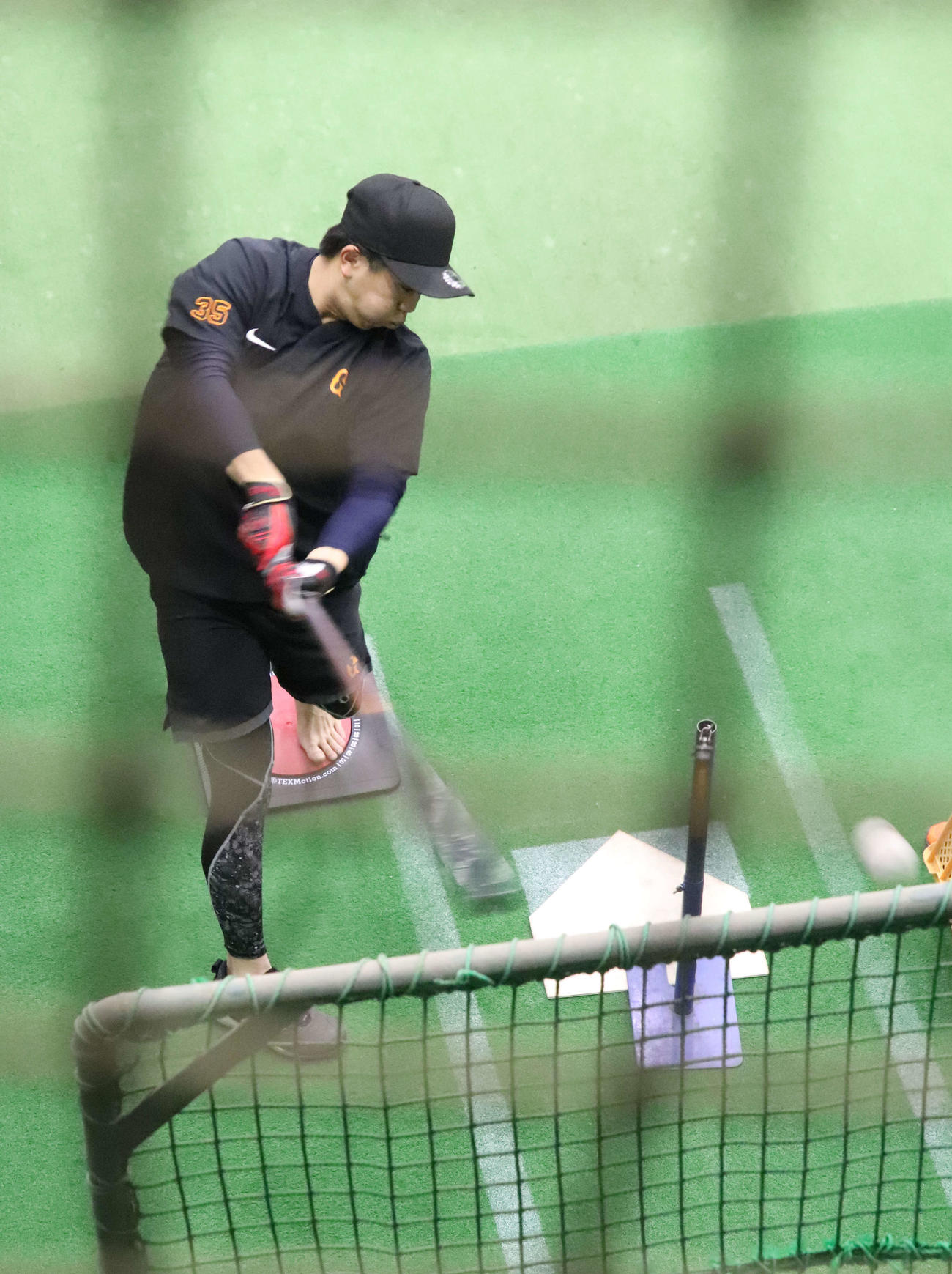 左足を回転する台に乗せてティー打撃する巨人門脇（撮影・小早川宗一郎）