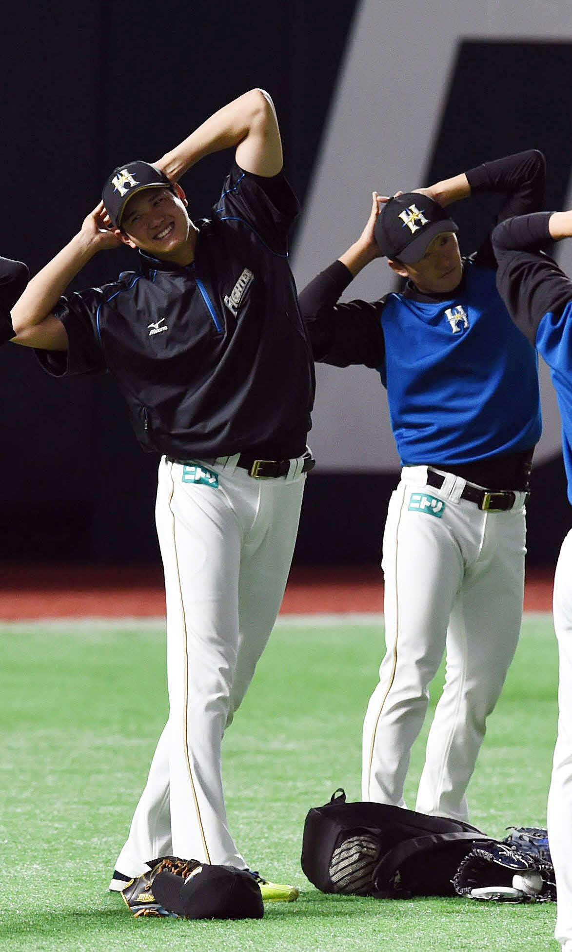 2015年6月、笑顔で準備体操をする大谷、右は斎藤