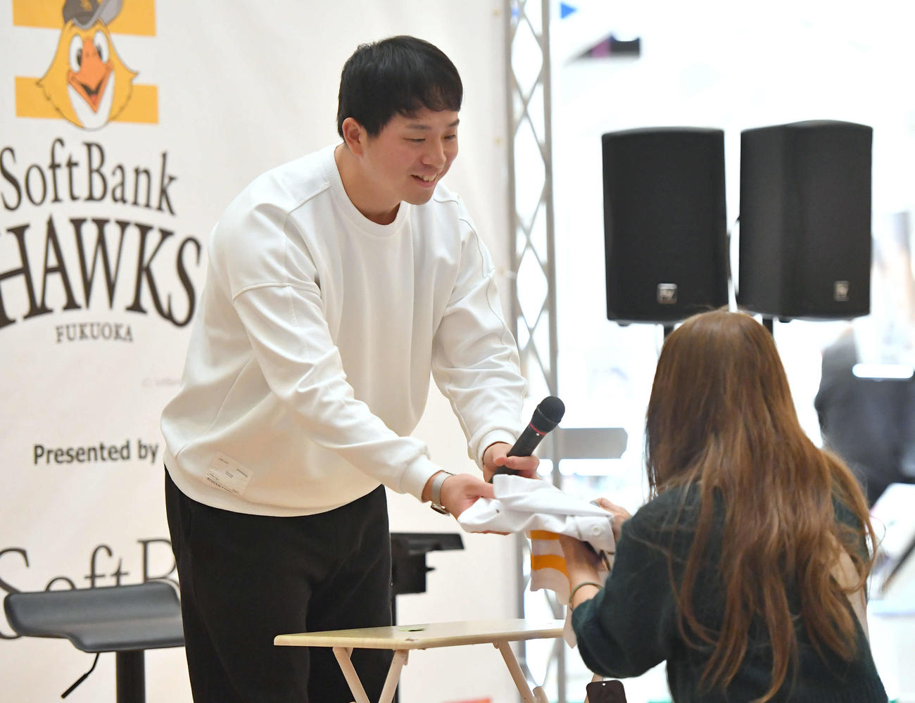 トークショーのプレゼント抽選会で当選したファンにサイン入りユニホームを手渡す大関（撮影・岩下翔太）