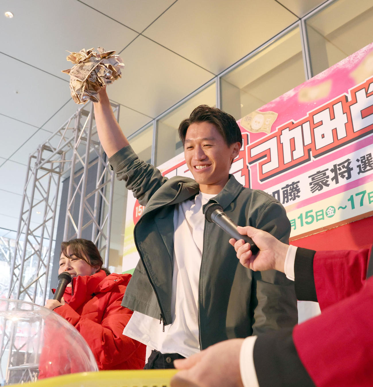 狸小路商店街で行われた「現金つかみ取り」に参加した日本ハム加藤豪はたくさんの1万円札を鷲づかみにし笑顔を見せる（撮影・佐藤翔太）