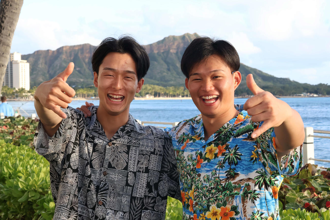 ダイヤモンドヘッドをバックにアロハポーズを決める森下（右）と小幡（撮影・古財稜明）