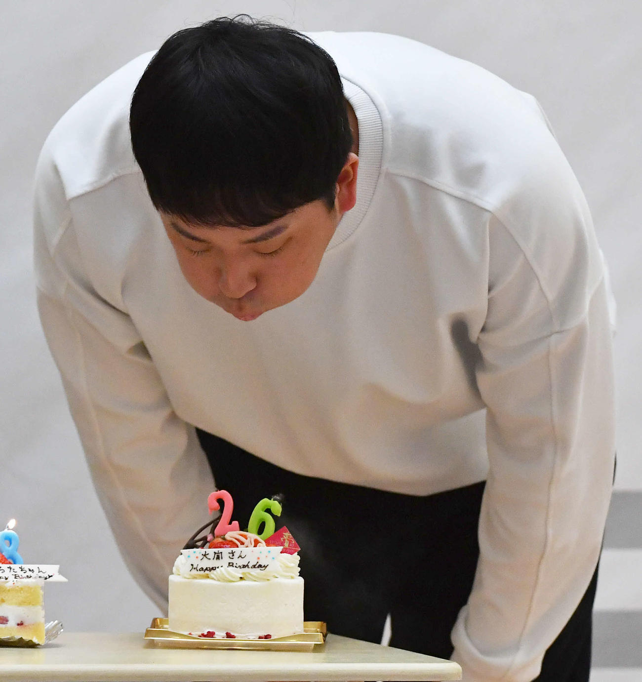 26歳を祝うケーキのろうそくを吹き消すソフトバンク大関（撮影・岩下翔太）