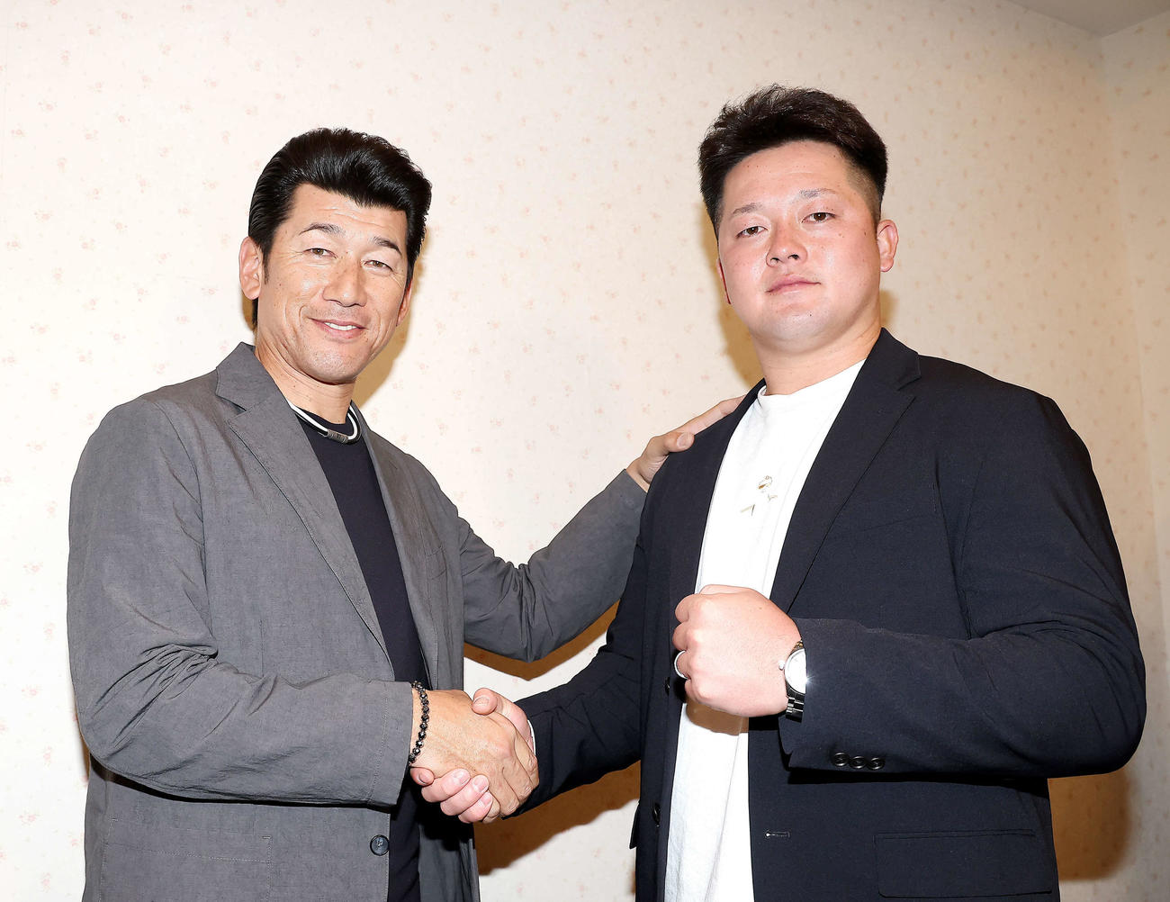 新キャプテンとなり、DeNA三浦監督（左）と握手を交わす牧（撮影・河田真司）