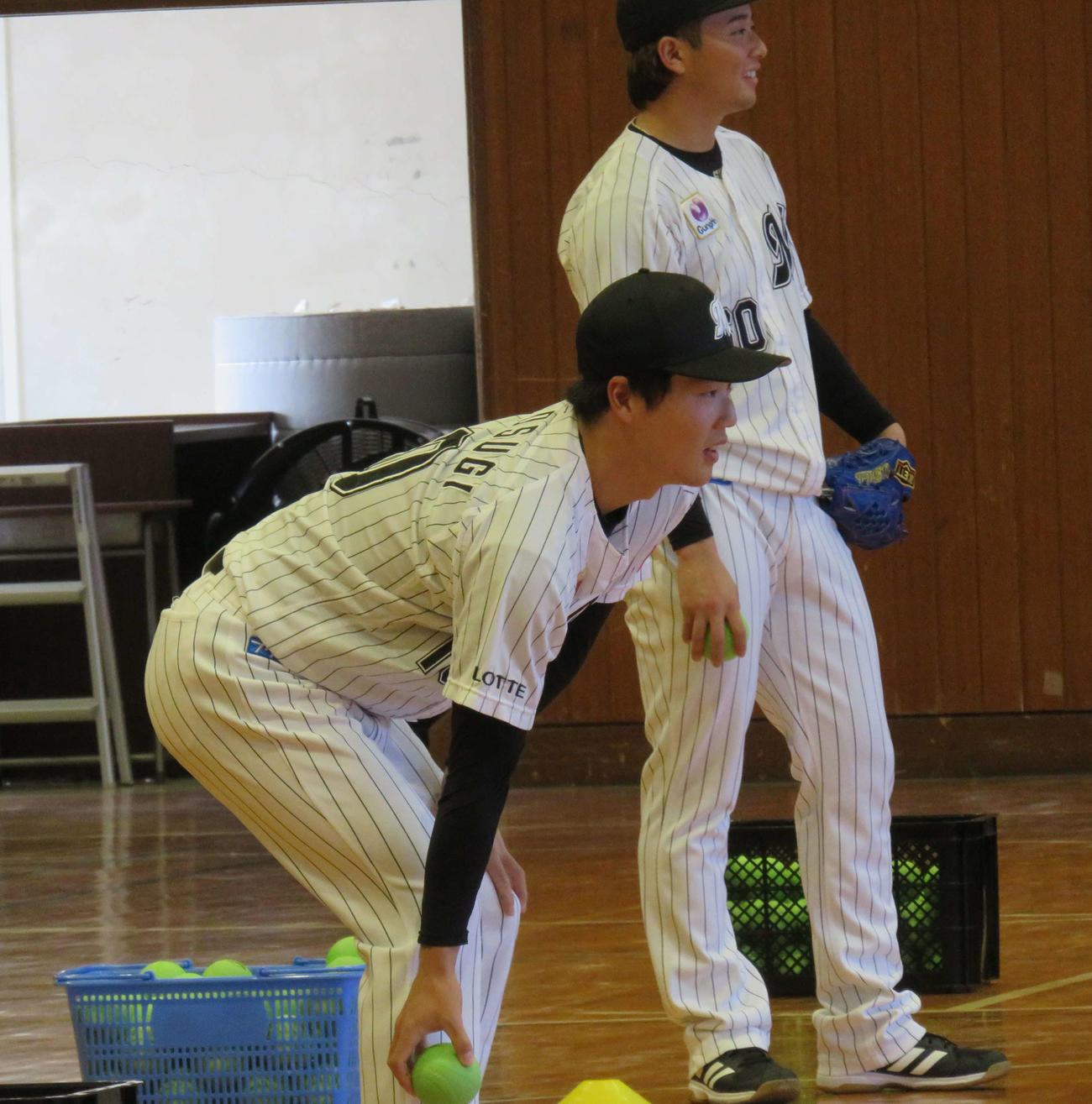 特別支援学校での野球体験型授業でトスを上げるロッテ友杉（左）。右は横山