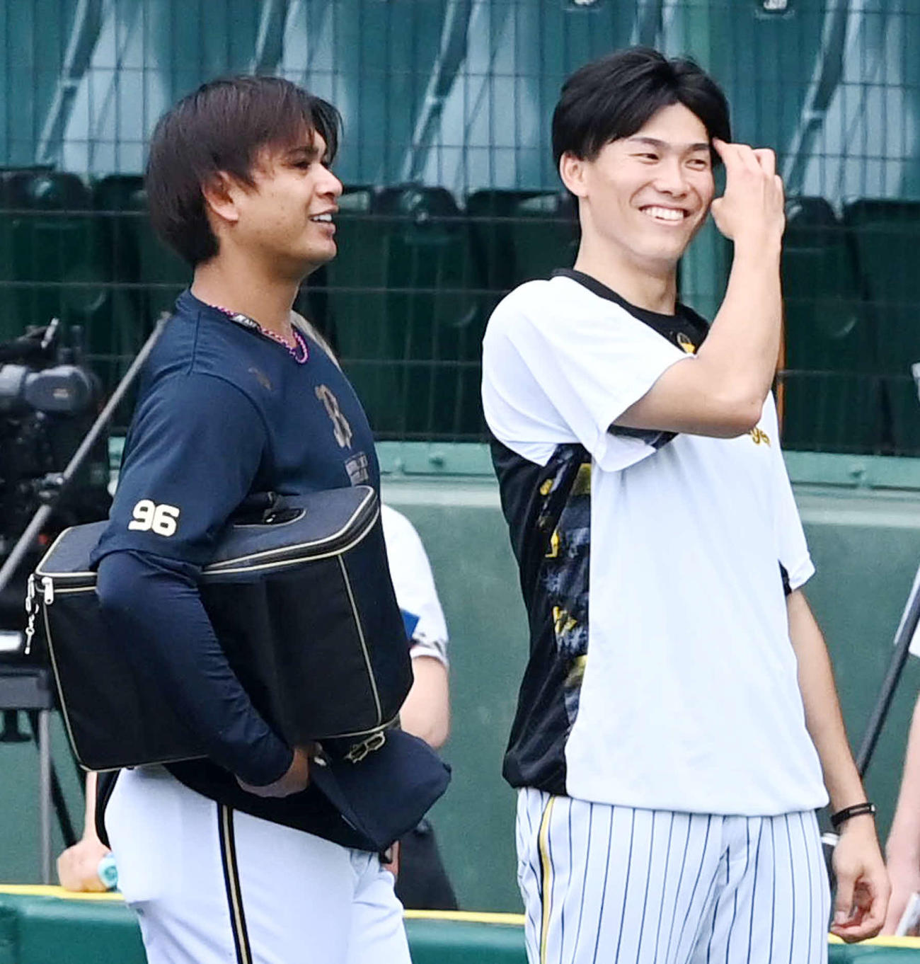 6月14日、試合前の練習中に笑顔で話すオリックス宇田川（左）と阪神湯浅