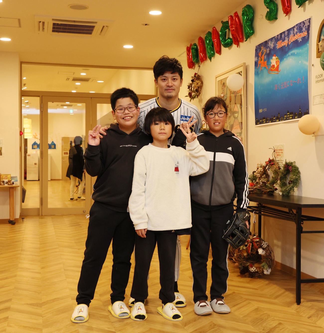 施設を訪問し入所利用者らとキャッチボールを楽しみ記念写真に納まる坂本（撮影・加藤哉）