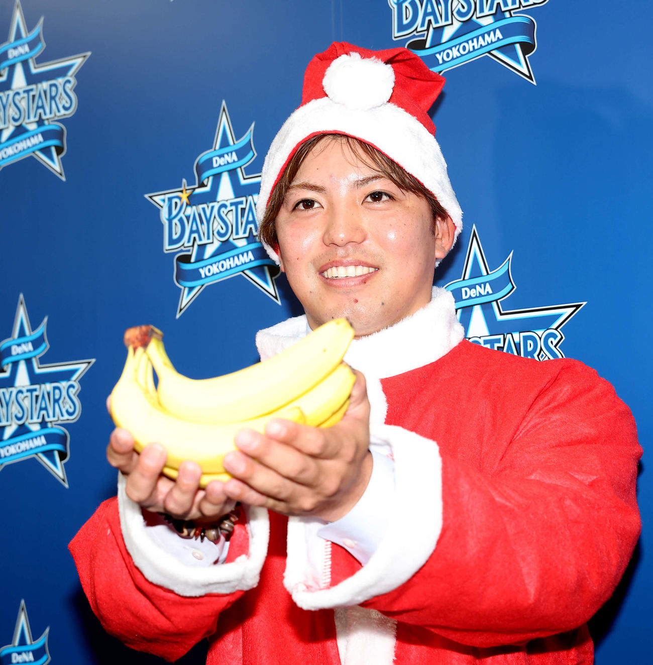 契約更改後、サンタの恰好でバナナを差し出すDeNA東（撮影・河田真司）