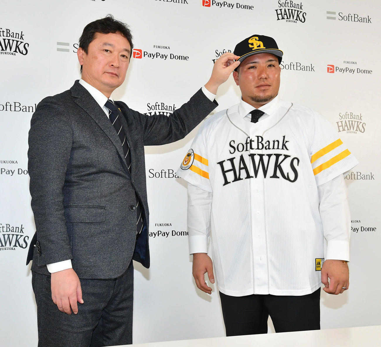 ソフトバンクへの入団会見を行い、三笠GM（左）に帽子をかぶせてもらう山川穂高（撮影・岩下翔太）