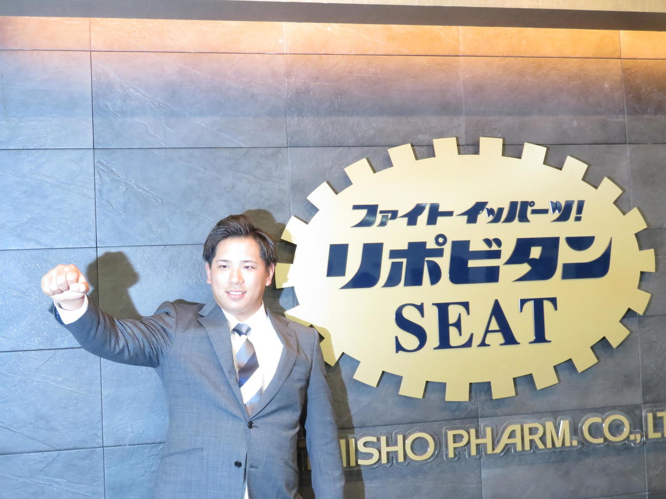入団会見を終えたロッテ愛斗はリポビタンシートの前で「あいと～、イッパーツ！」のポーズ