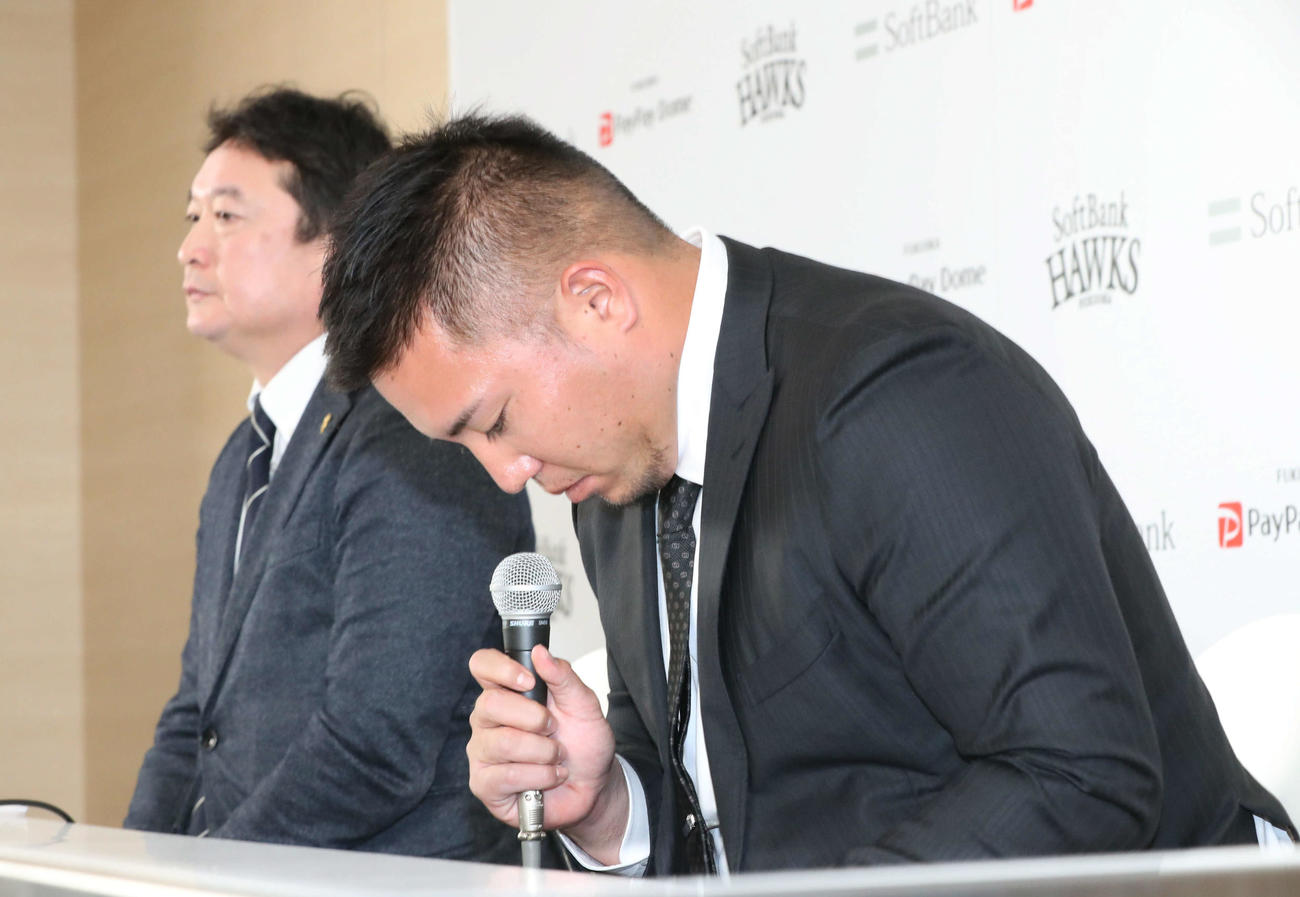 ソフトバンク入団会見で頭を下げる山川（手前）。後方は三笠GM（撮影・岩下翔太）