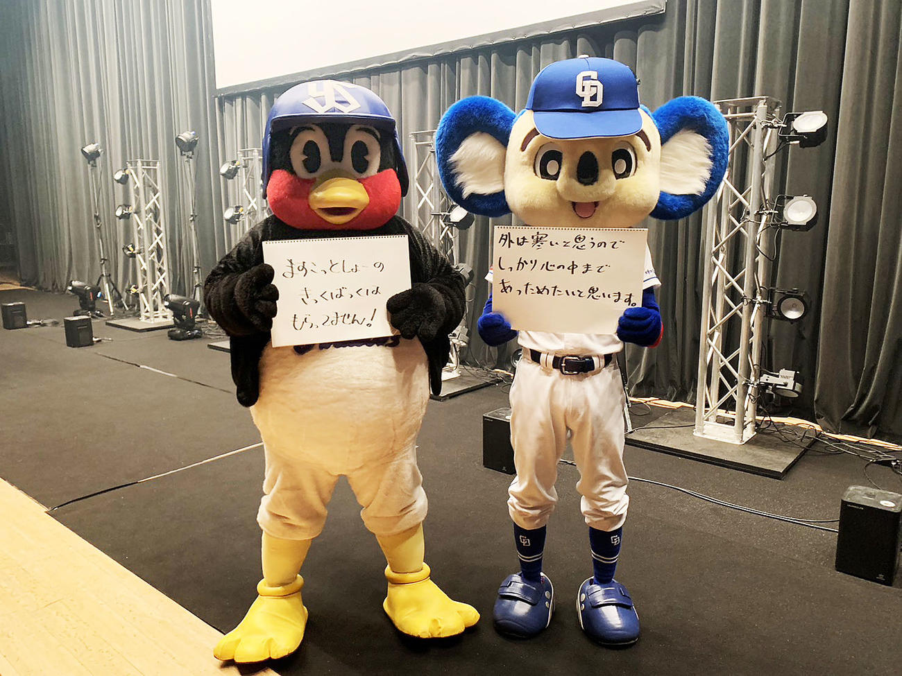 名古屋公演スタート前にフリップを手にする（左から）ドアラ、つば九郎（中日ドラゴンズ球団提供）