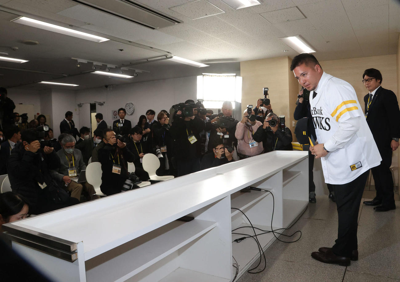 ソフトバンク入団会見を終え、ユニホームを着て報道陣、関係者に頭を下げて引き揚げる山川（撮影・梅根麻紀）