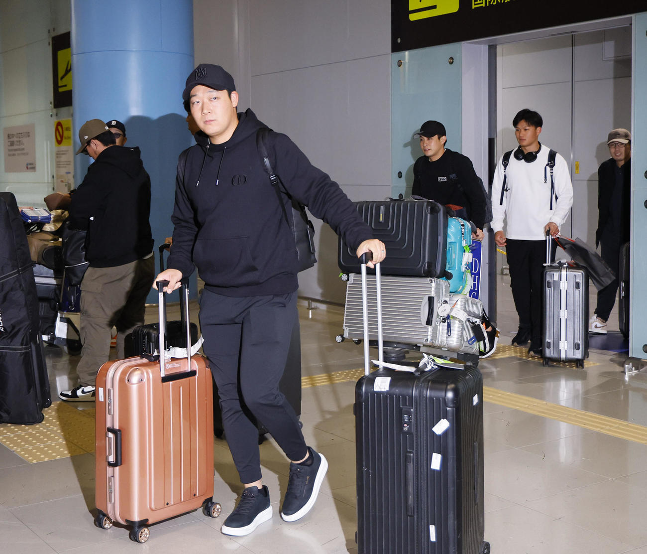 V旅行先のハワイから帰国した大山悠輔。右奥左から木浪、森下（撮影・藤尾明華）