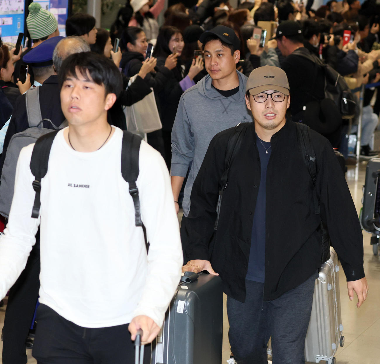 優勝旅行から帰国した馬場。左は才木、右は大竹（撮影・加藤哉）