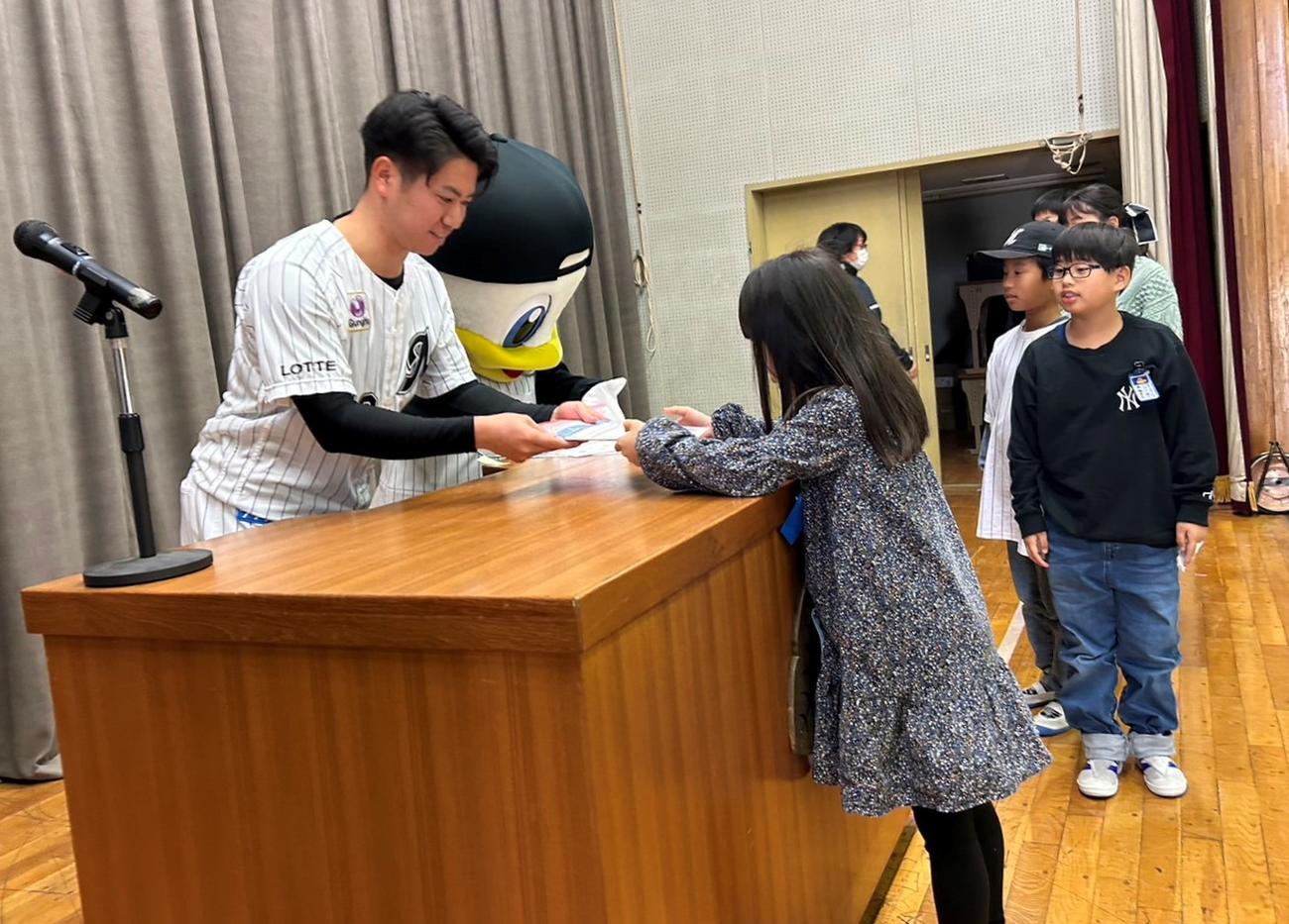 マリーンズ算数ドリルを贈呈する秋山（撮影・星夏穂）