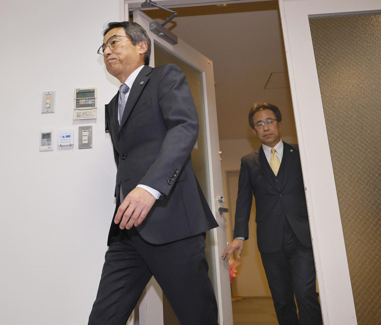 会見場に入る阪神の百北球団社長（左）と、次期社長に就任する粟井副社長（撮影・藤尾明華）