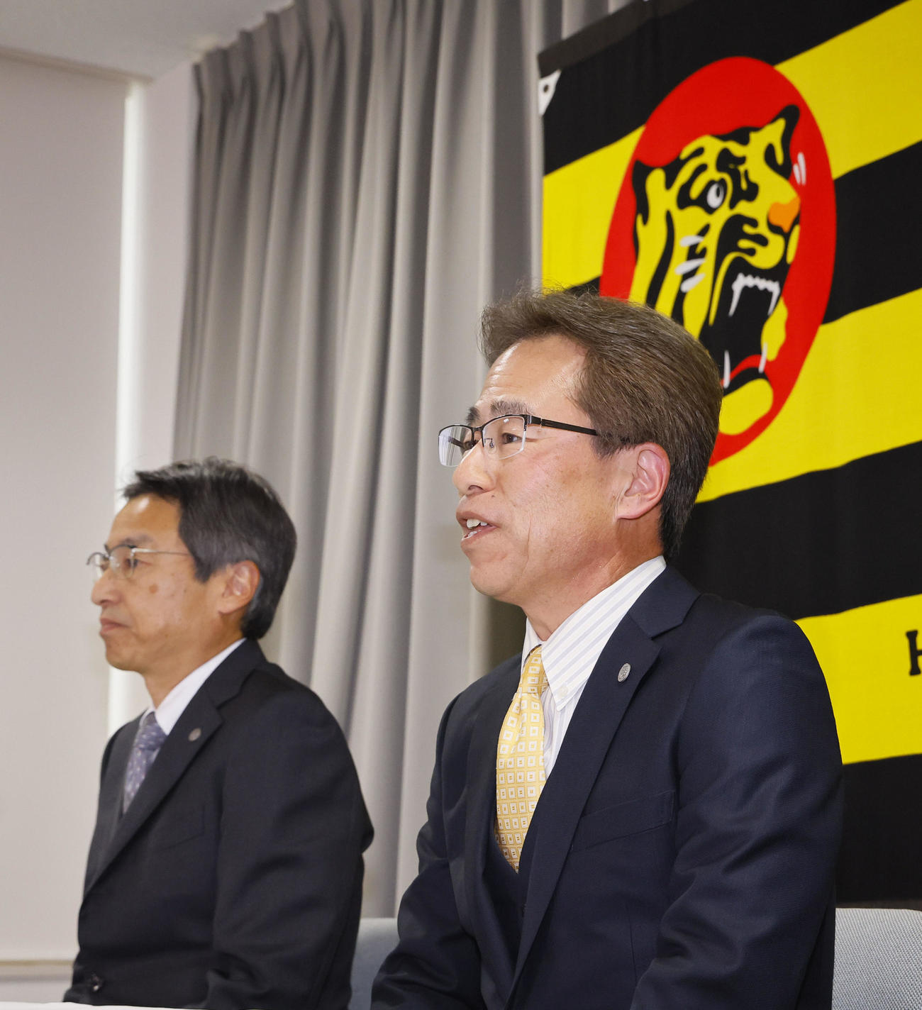 阪神の次期球団社長に決まり、記者会見する粟井副社長（右）。左は百北球団社長（撮影・藤尾明華）