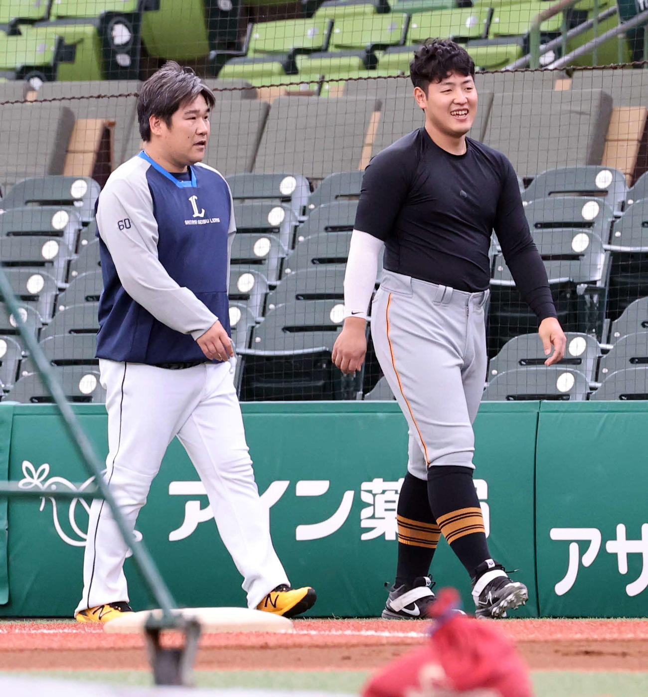 1軍の練習のみ合流した西武中村剛也（左）は巨人岡本和真と談笑しながら歩く（2022年6月撮影）
